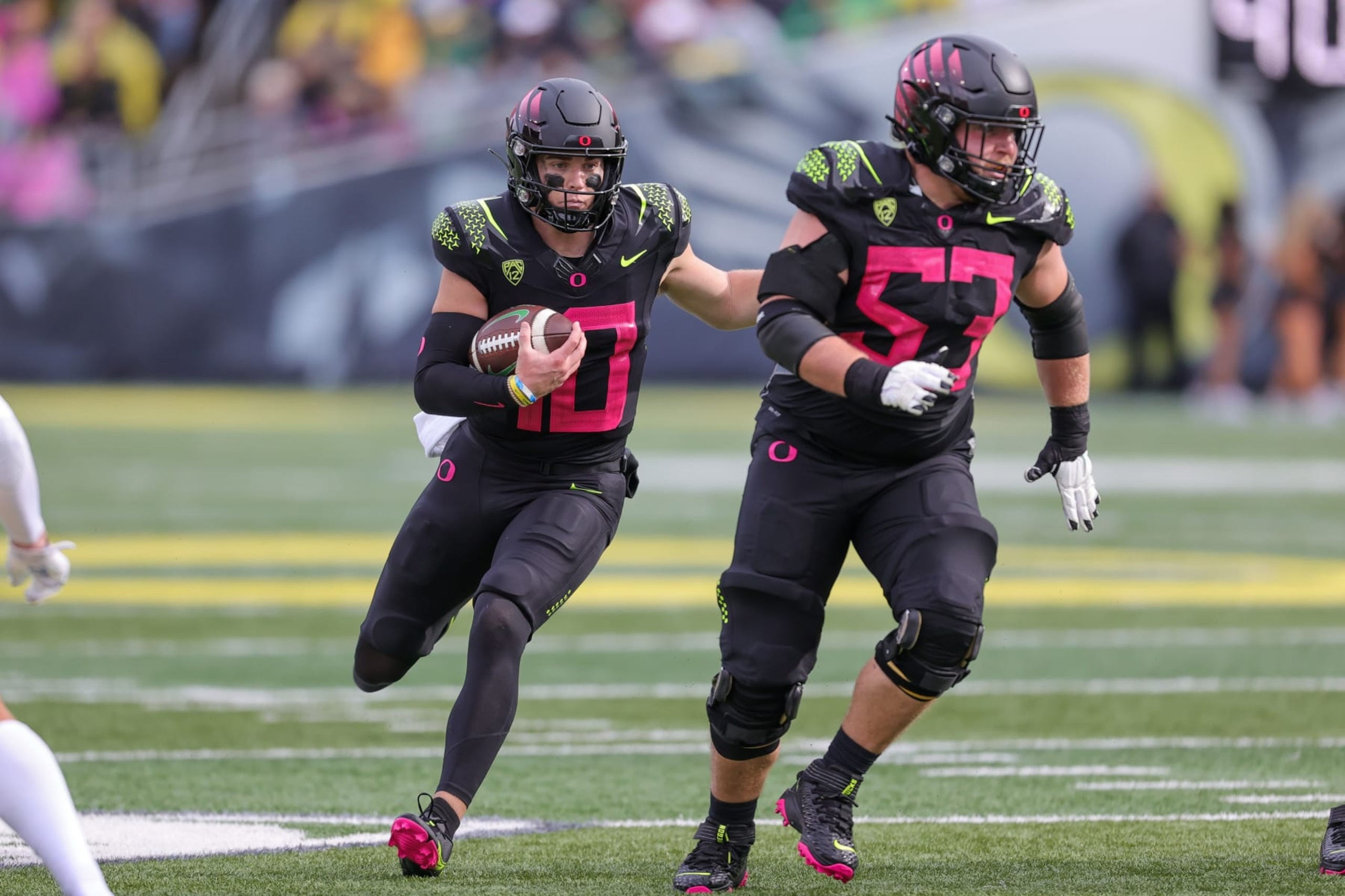 EUGENE, OR - OCTOBER 22: Oregon Ducks quarterback Bo Nix (10) runs behind the blocking of Oregon Ducks offensive lineman Ryan Walk (53)j against the UCLA Bruins defense during the second half of a college football game between the Oregon Ducks and UCLA Bruins on October 22, 2022 at Autzen Stadium in Eugene, OR. (Photo by Steve Conner/Icon Sportswire via Getty Images)