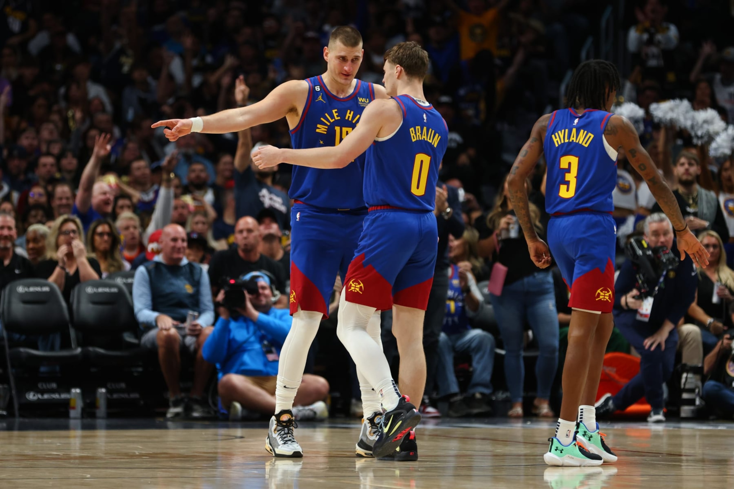 DENVER, CO - OCTOBER 22: Nikola Jokic #15 and Christian Braun #0 of the Denver Nuggets talk during a timeout in the game against the Oklahoma City Thunder at Ball Arena on October 22, 2022 in Denver, Colorado. NOTE TO USER: User expressly acknowledges and agrees that, by downloading and or using this Photograph, User is consenting to the terms and conditions of the Getty Images License Agreement. Mandatory Copyright Notice: Copyright 2022 NBAE (Photo by Justin Tafoya/Getty Images)