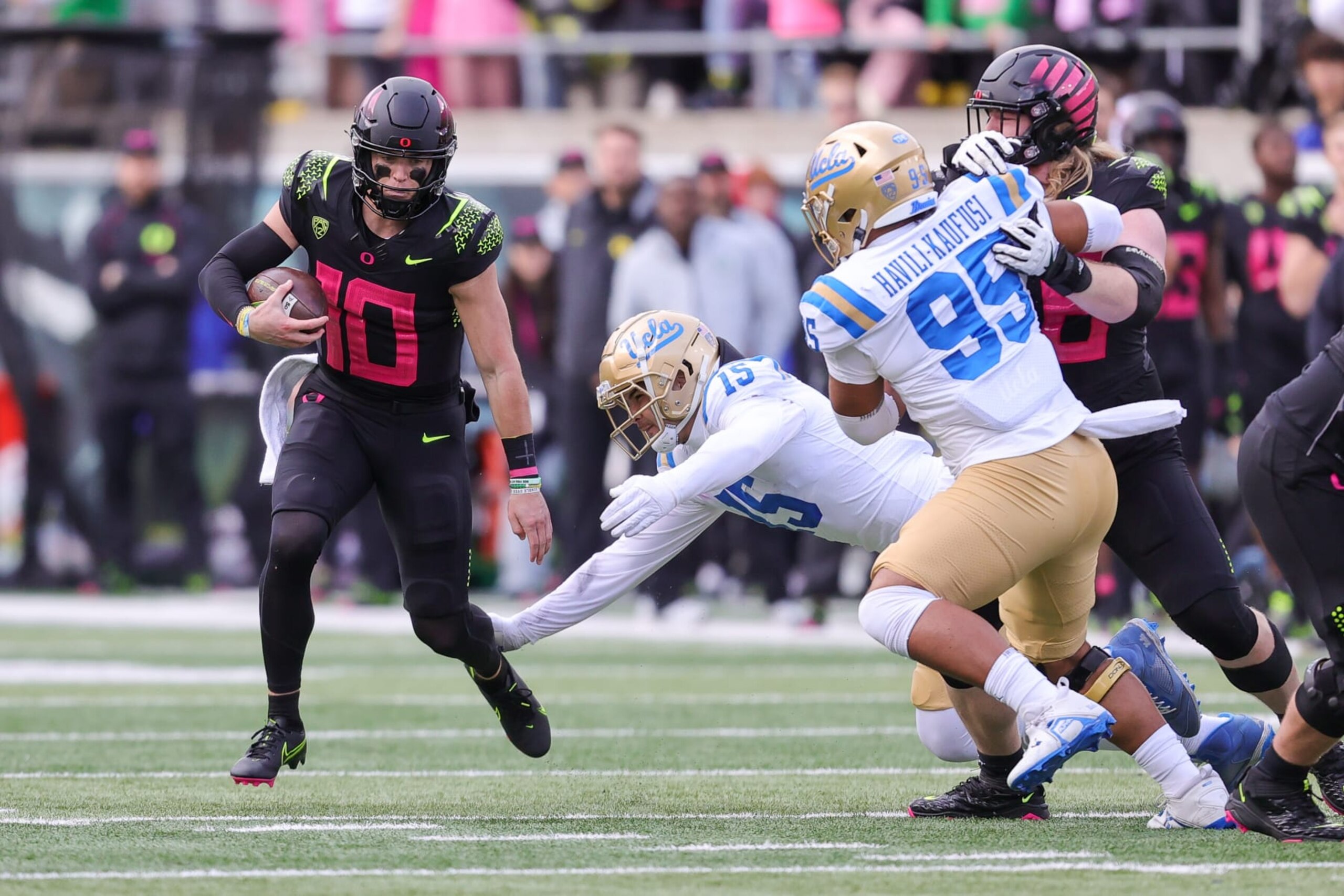 EUGENE, OR - OCTOBER 22: Oregon Ducks quarterback Bo Nix (10) scrambles away from the arms of UCLA Bruins linebacker Laiatu Latu (15) and the pressure by UCLA Bruins defensive lineman Jacob Sykes (99) during the second half of a college football game between the Oregon Ducks and UCLA Bruins on October 22, 2022 at Autzen Stadium in Eugene, OR. (Photo by Steve Conner/Icon Sportswire via Getty Images)