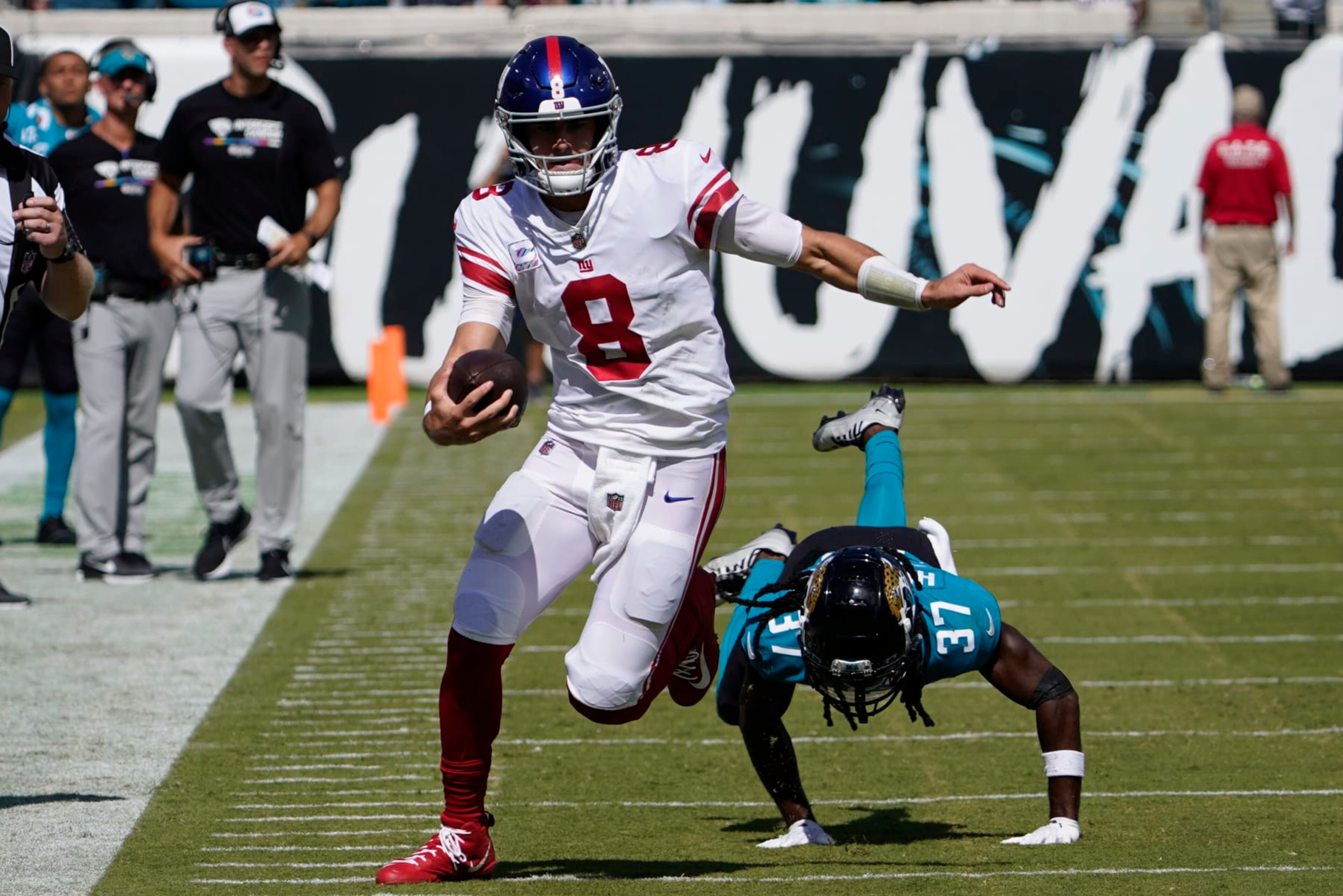 New York Giants quarterback Daniel Jones (8) scrambles away from Jacksonville Jaguars cornerback Tre Herndon (37) during the first half of an NFL football game Sunday, Oct. 23, 2022, in Jacksonville, Fla. (AP Photo/John Raoux)
