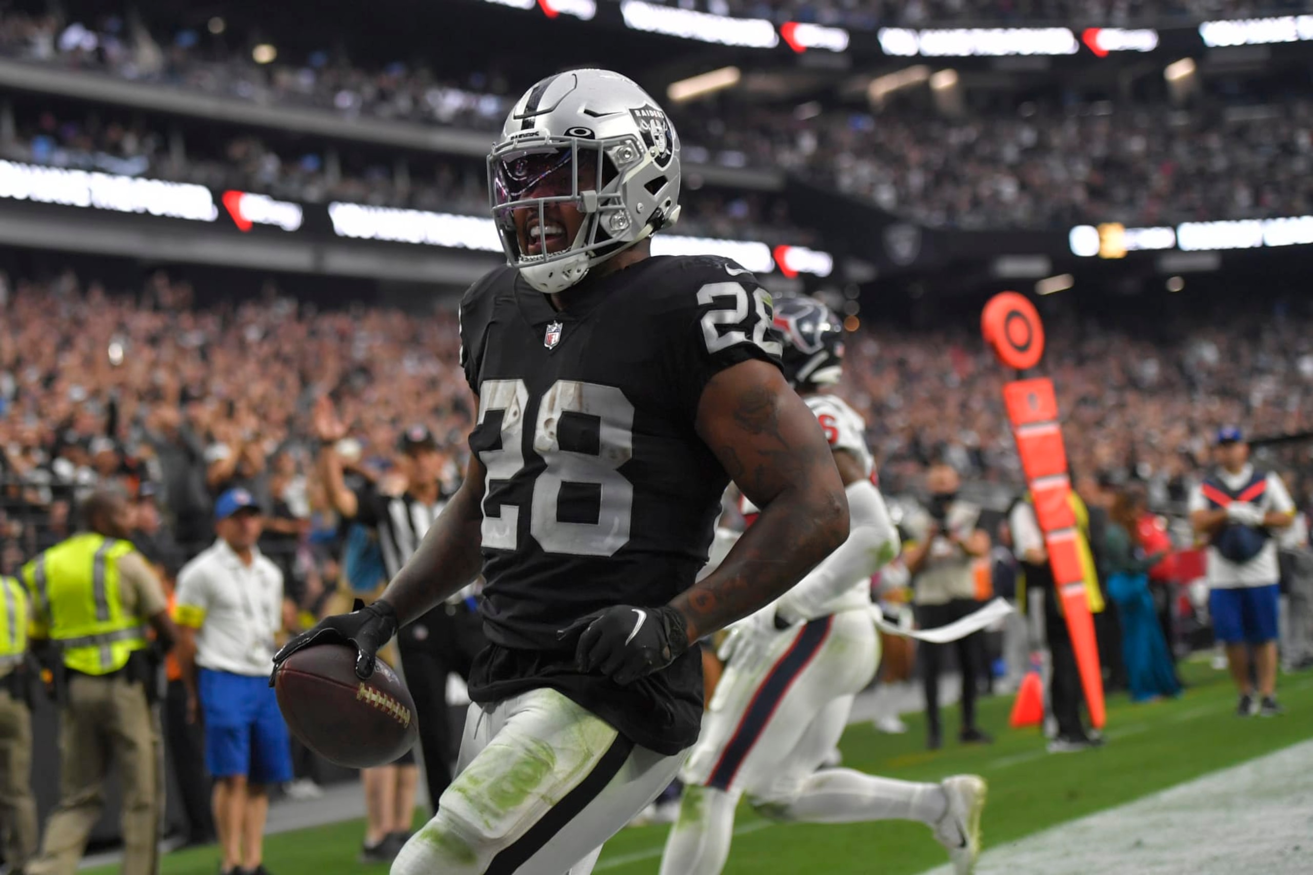Las Vegas Raiders running back Josh Jacobs, left, scores a touchdown as Houston Texans safety Jonathan Owens defends during the second half of an NFL football game Sunday, Oct. 23, 2022, in Las Vegas. (AP Photo/David Becker)