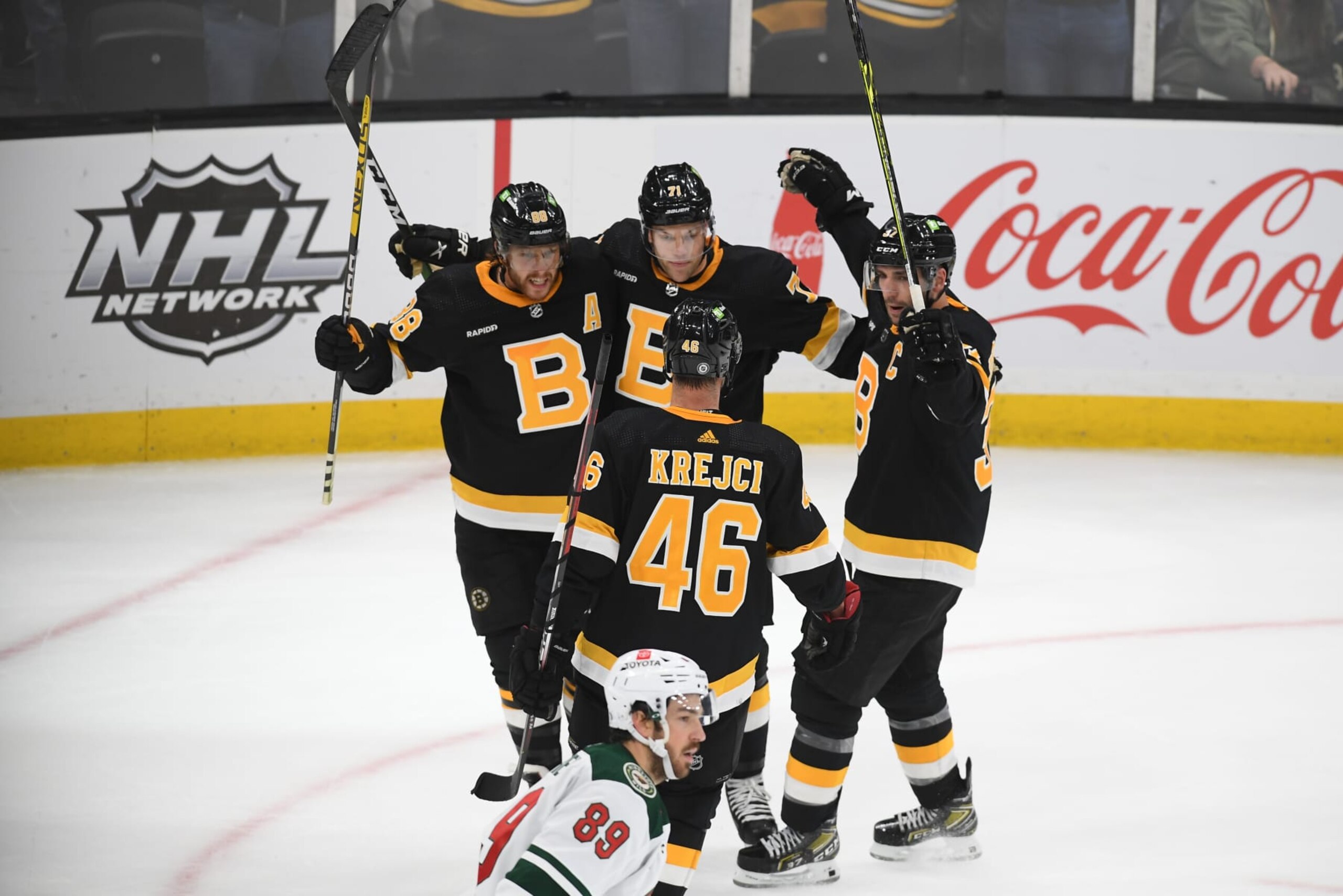 BOSTON, MASSACHUSETTS - OCTOBER 22: David Pastrnak #88, Taylor Hall #71, Patrice Bergeron #37 and David Krejci #46 of the Boston Bruins celebrate the overtime goal against the Minnesota Wild at the TD Garden on October 22, 2022 in Boston, Massachusetts. (Photo by Steve Babineau/NHLI via Getty Images)