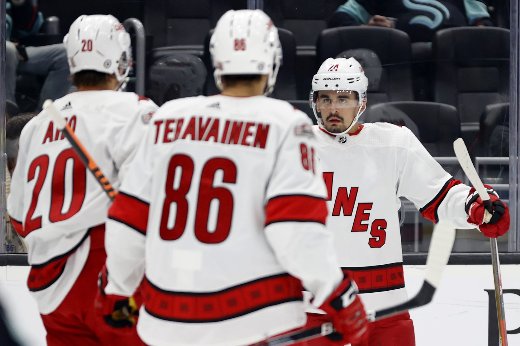 SEATTLE, WASHINGTON - OCTOBER 17: Seth Jarvis #24 of the Carolina Hurricanes celebrates his goal with Sebastian Aho #20 and Teuvo Teravainen #86 during the first period against the Seattle Kraken at Climate Pledge Arena on October 17, 2022 in Seattle, Washington. (Photo by Steph Chambers/Getty Images)