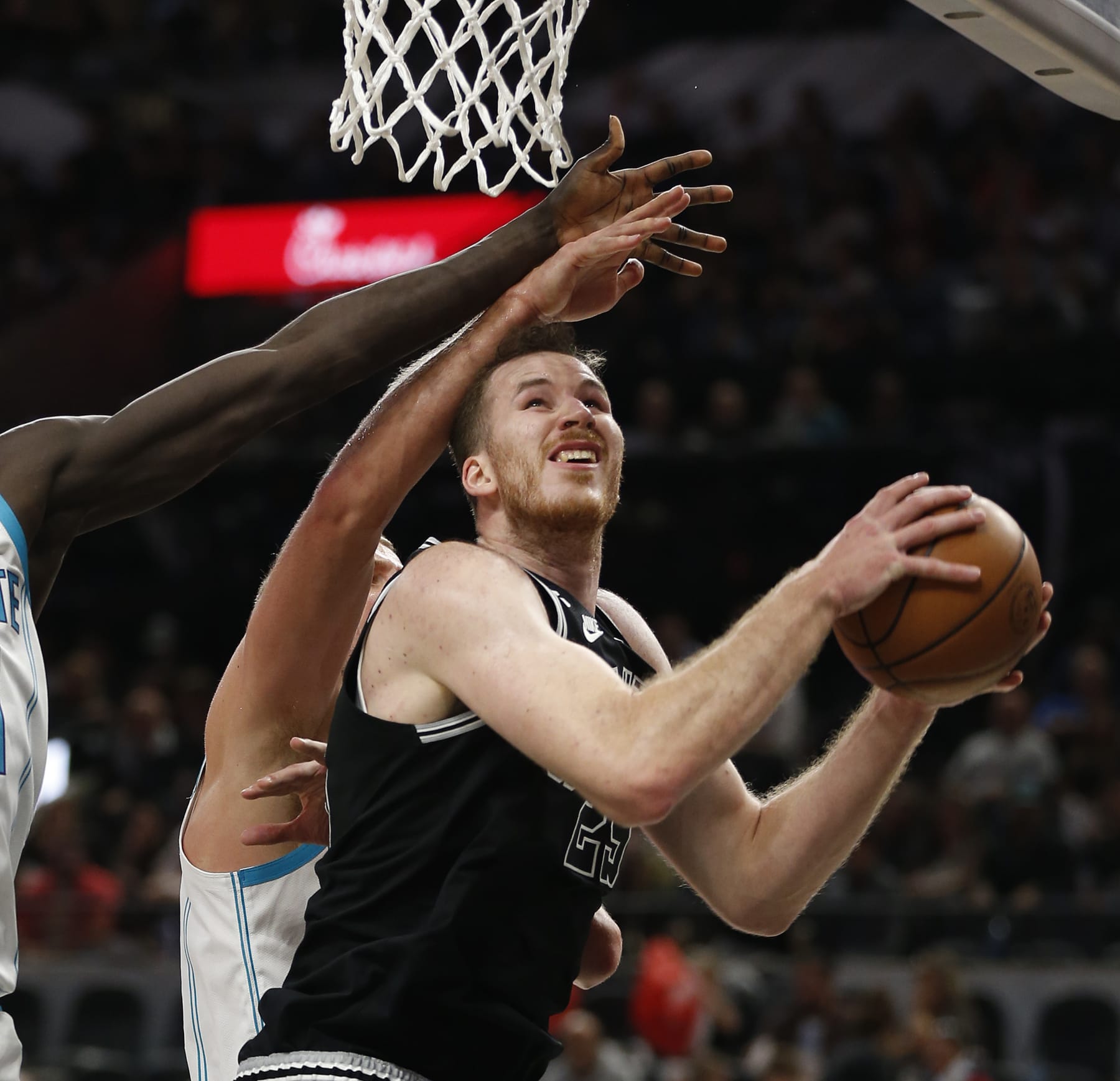 SAN ANTONIO, TX - OCTOBER 19: Jakob Poeltl #25 of the San Antonio Spurs scores past Charlotte Hornets defenders in the second half at AT&T Center on October 19,  2022 in San Antonio, Texas. NOTE TO USER: User expressly acknowledges and agrees that, by downloading and or using this photograph, User is consenting to terms and conditions of the Getty Images License Agreement. (Photo by Ronald Cortes/Getty Images)