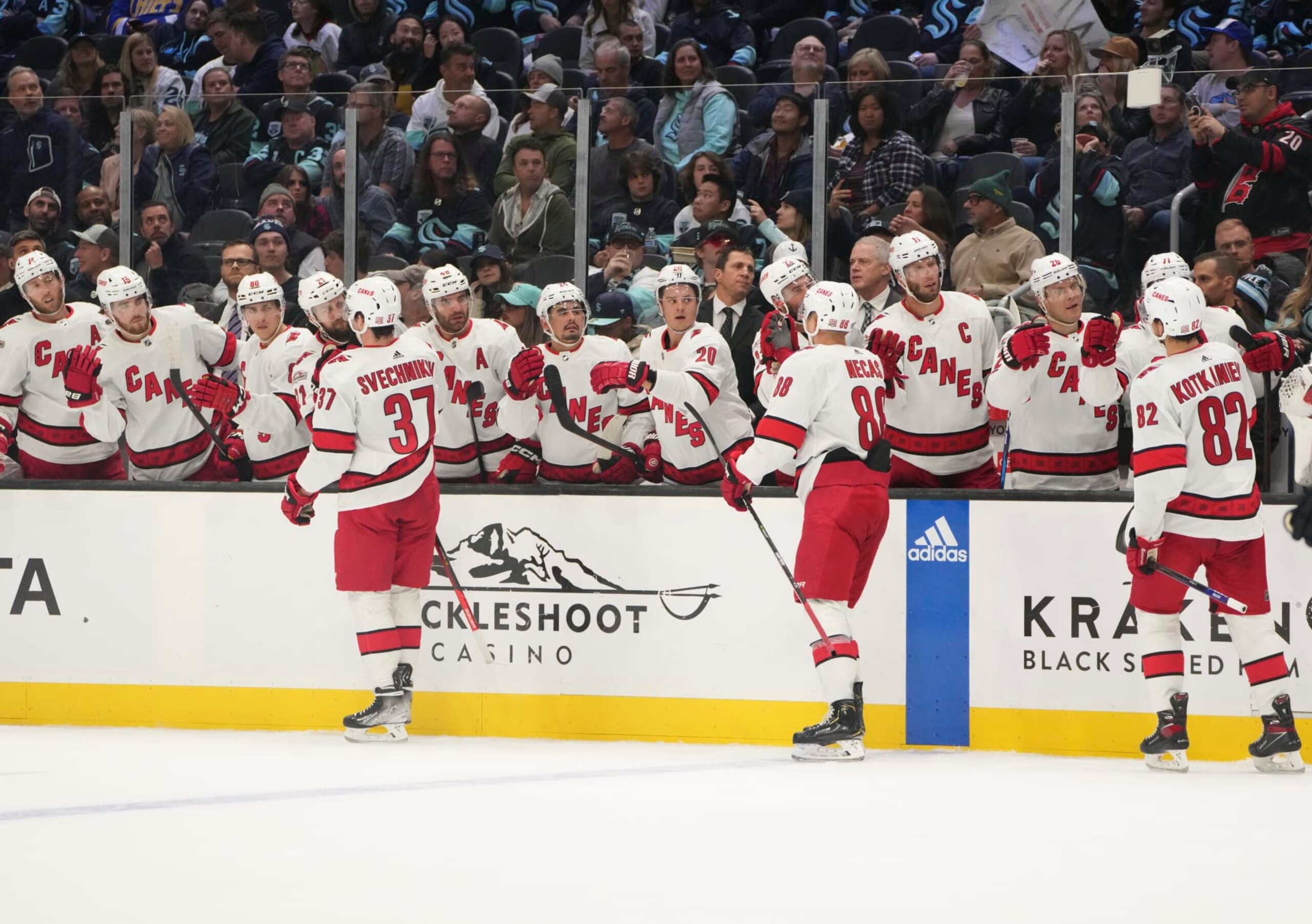 SEATTLE, WA - OCTOBER 17: Carolina Hurricanes right wing Andrei Svechnikov (37), center Derek Stepan (18) and forward Jesperi Kotkaniemi (82) celebrate a Hurricane goal with teammates during an NHL game between the Carolina Hurricanes and the Seattle Kraken on October 17, 2022 at Climate Pledge Arena in Seattle, WA. (Photo by Jeff Halstead/Icon Sportswire via Getty Images)