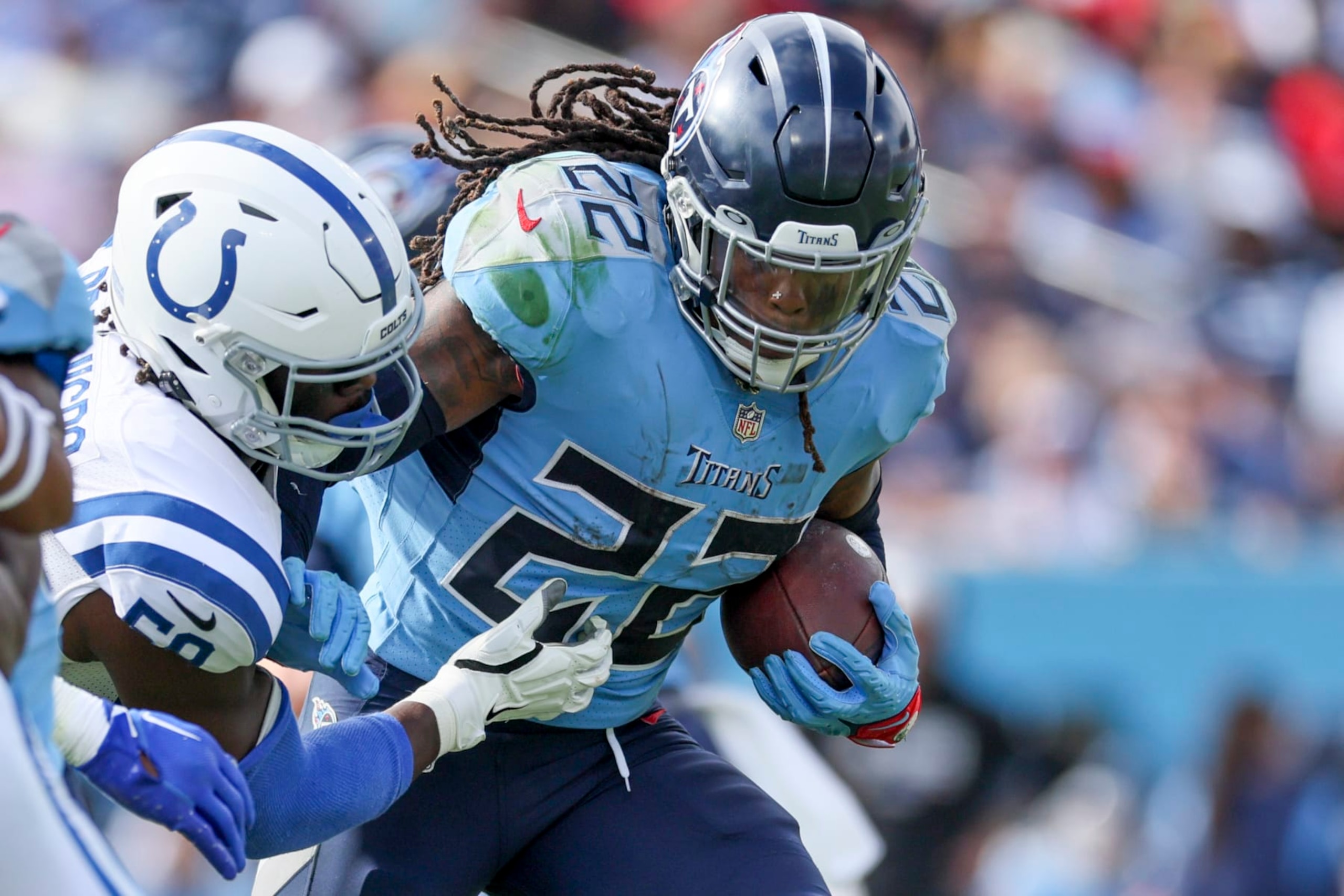 NASHVILLE, TENNESSEE - OCTOBER 23: Derrick Henry #22 of the Tennessee Titans runs with the ball against Ifeadi Odenigbo #59 of the Indianapolis Colts during the first half at Nissan Stadium on October 23, 2022 in Nashville, Tennessee. (Photo by Andy Lyons/Getty Images)