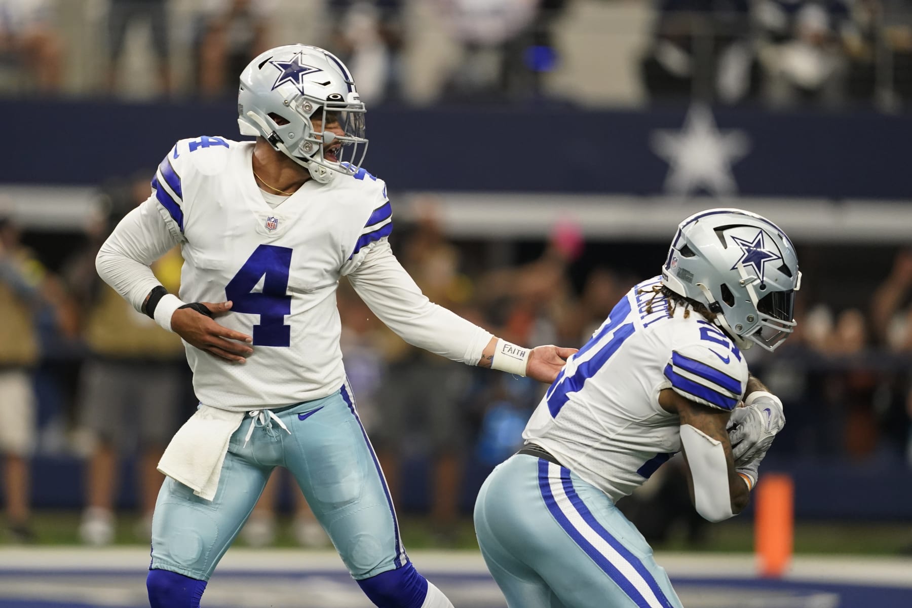 Dallas Cowboys quarterback Dak Prescott (4) hands off to running back Ezekiel Elliott (21) for a touchdown during the second half of an NFL football game against the Detroit Lions, Sunday, Oct. 23, 2022, in Arlington, Texas. (AP Photo/Tony Gutierrez)