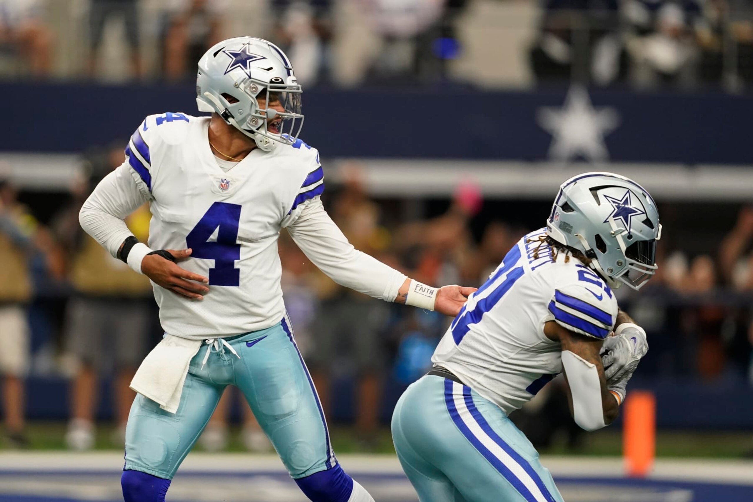 Dallas Cowboys quarterback Dak Prescott (4) hands off to running back Ezekiel Elliott (21) for a touchdown during the second half of an NFL football game against the Detroit Lions, Sunday, Oct. 23, 2022, in Arlington, Texas. (AP Photo/Tony Gutierrez)