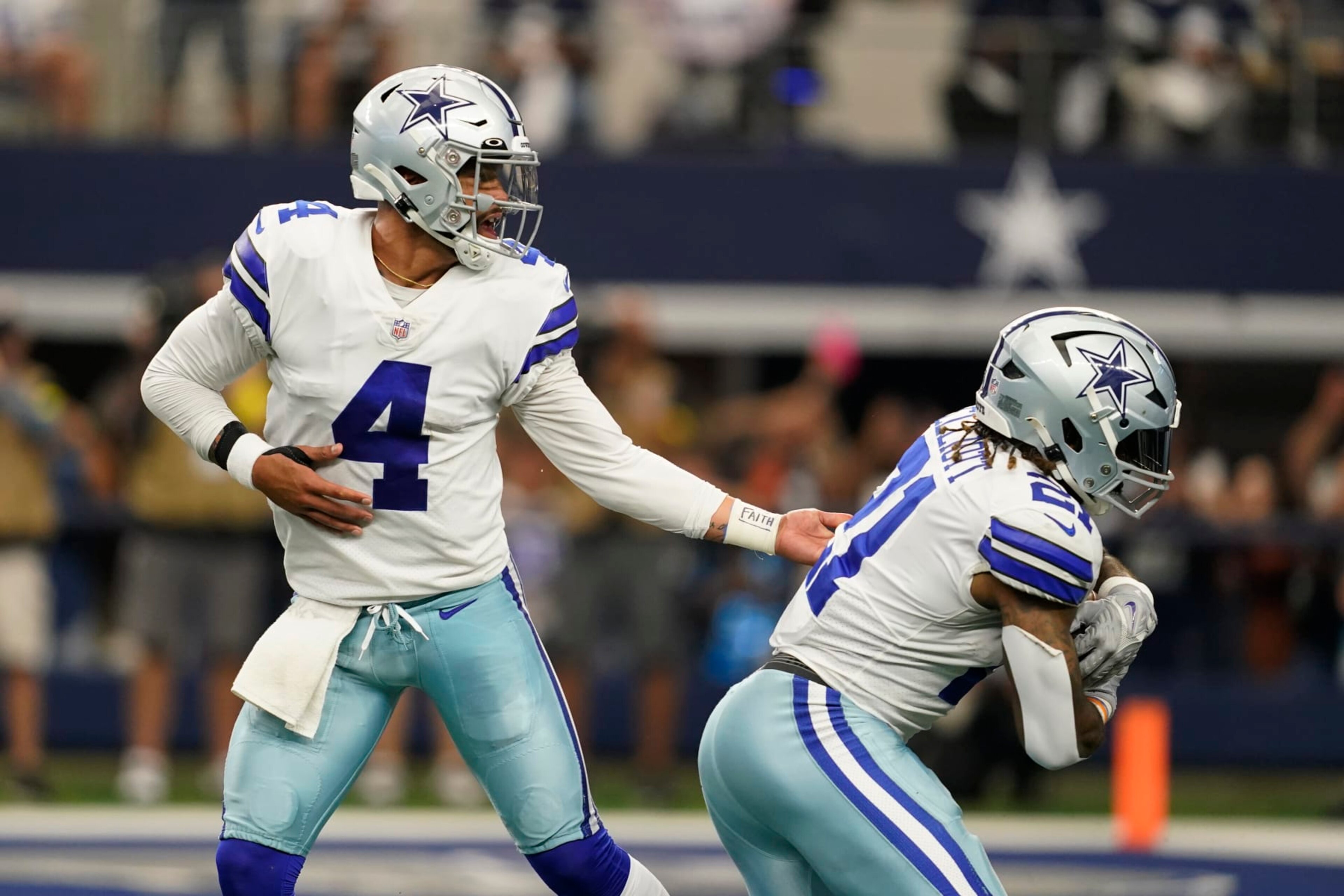 Dallas Cowboys quarterback Dak Prescott (4) hands off to running back Ezekiel Elliott (21) for a touchdown during the second half of an NFL football game against the Detroit Lions, Sunday, Oct. 23, 2022, in Arlington, Texas. (AP Photo/Tony Gutierrez)