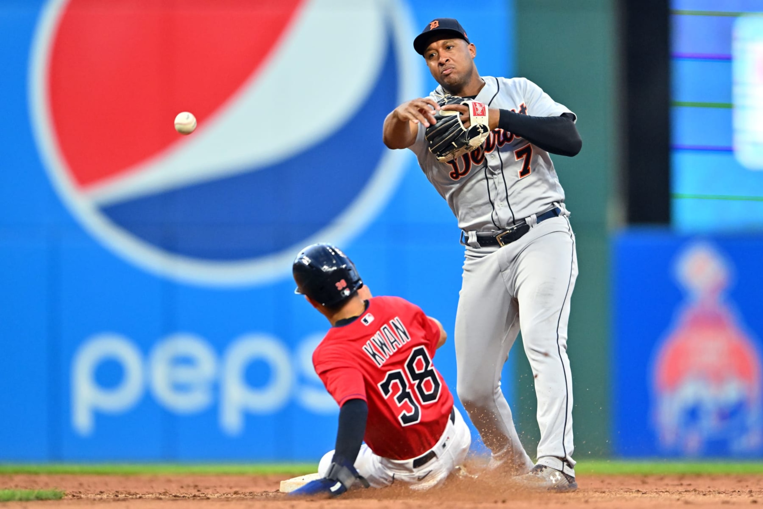 CLEVELAND, OHIO - AUGUST 15: Second baseman Jonathan Schoop #7 of the Detroit Tigers turns a double play over Steven Kwan #38 of the Cleveland Guardians at second in the fifth inning of the second game of a doubleheader at Progressive Field on August 15, 2022 in Cleveland, Ohio. (Photo by Jason Miller/Getty Images)