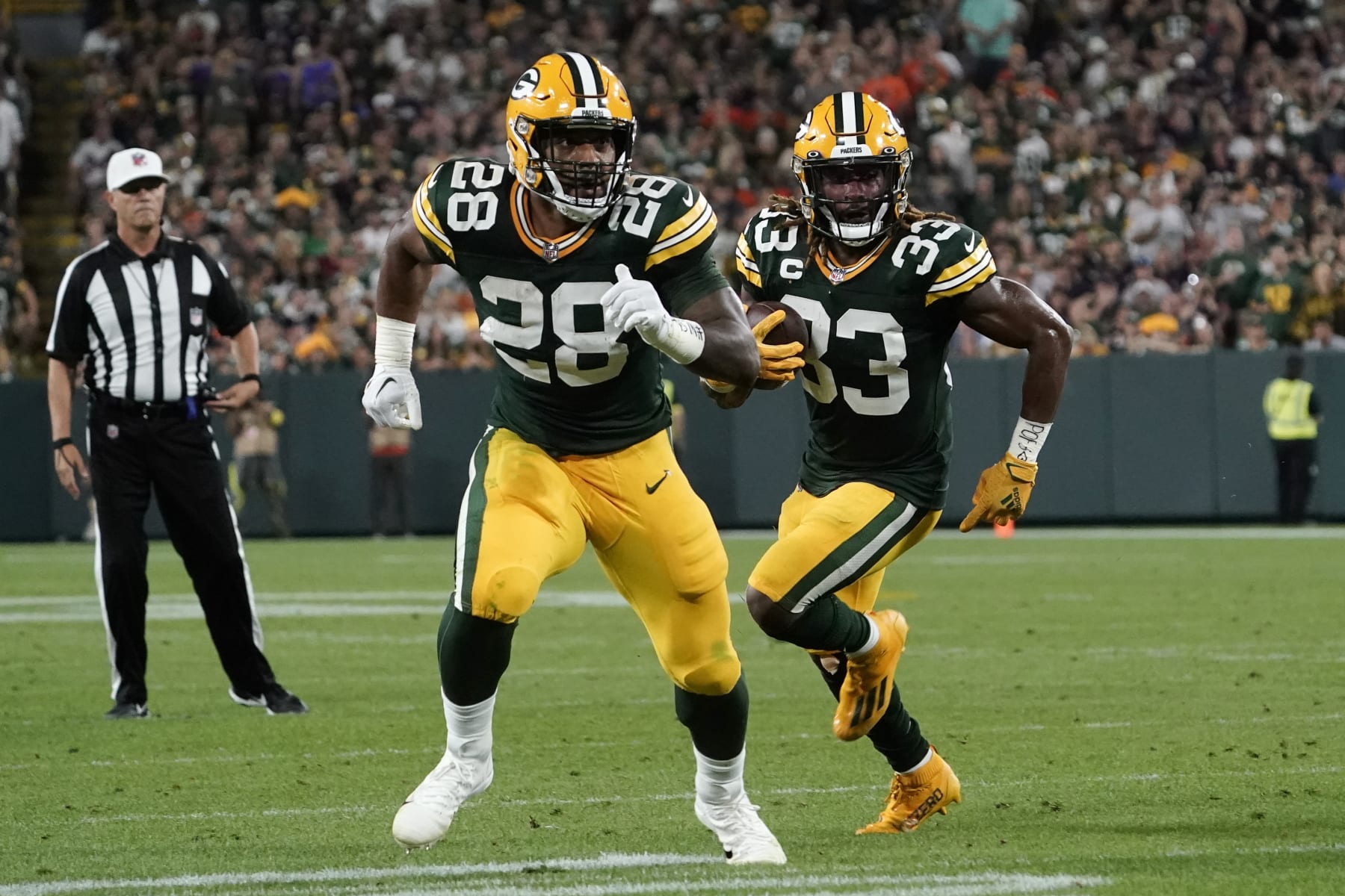 Green Bay Packers running back Aaron Jones (33) runs behind teammate running back AJ Dillon (28) during an 8-yard touchdown reception during the first half of an NFL football game against the Chicago Bears Sunday, Sept. 18, 2022, in Green Bay, Wis. (AP Photo/Morry Gash)