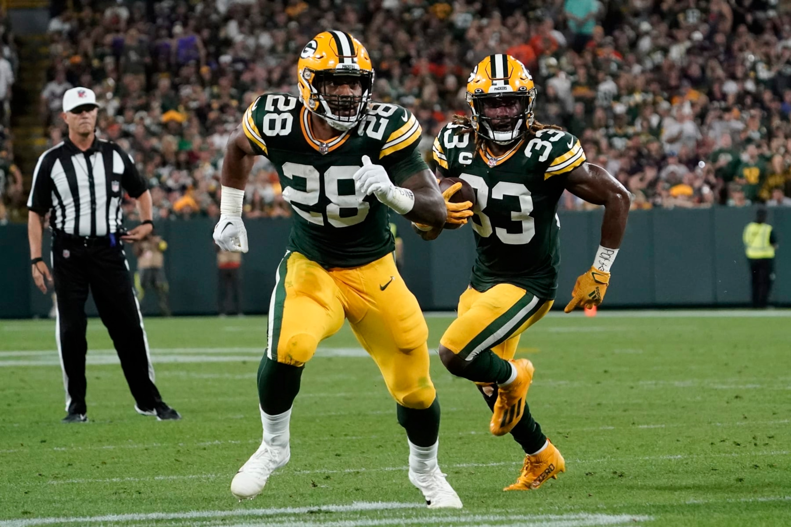 Green Bay Packers running back Aaron Jones (33) runs behind teammate running back AJ Dillon (28) during an 8-yard touchdown reception during the first half of an NFL football game against the Chicago Bears Sunday, Sept. 18, 2022, in Green Bay, Wis. (AP Photo/Morry Gash)