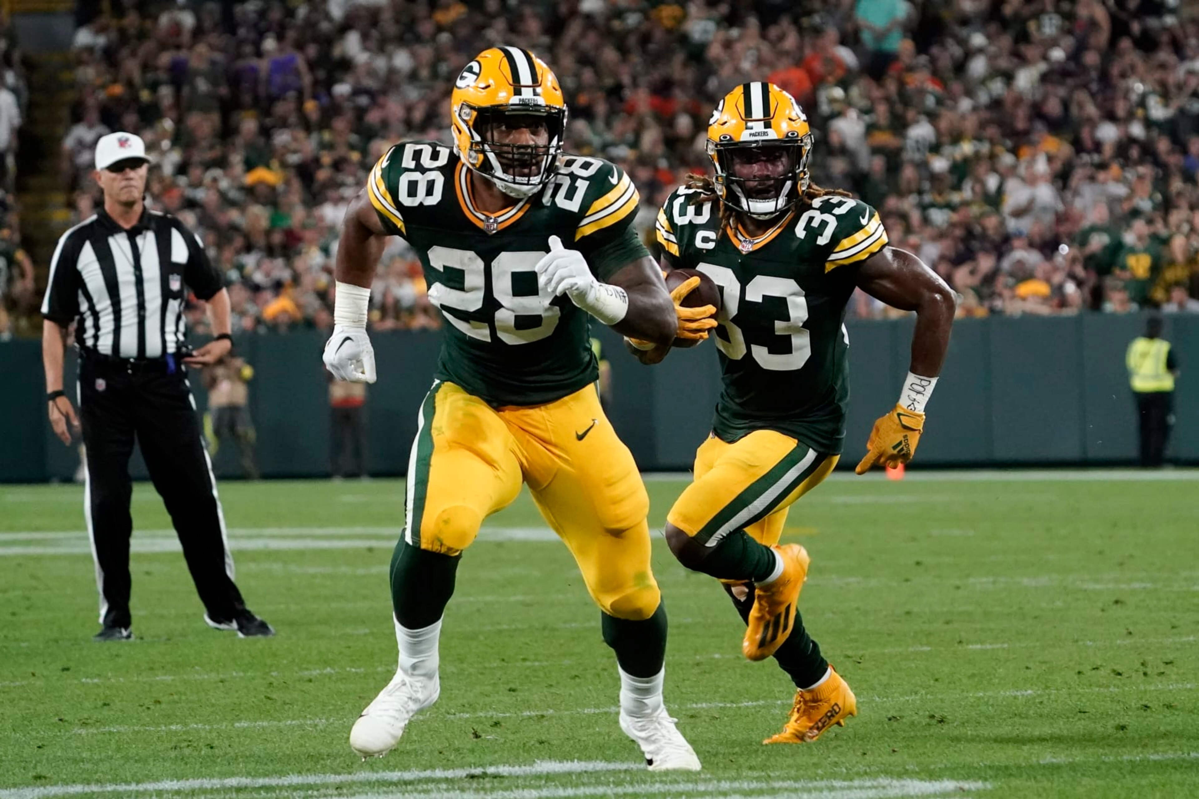 Green Bay Packers running back Aaron Jones (33) runs behind teammate running back AJ Dillon (28) during an 8-yard touchdown reception during the first half of an NFL football game against the Chicago Bears Sunday, Sept. 18, 2022, in Green Bay, Wis. (AP Photo/Morry Gash)