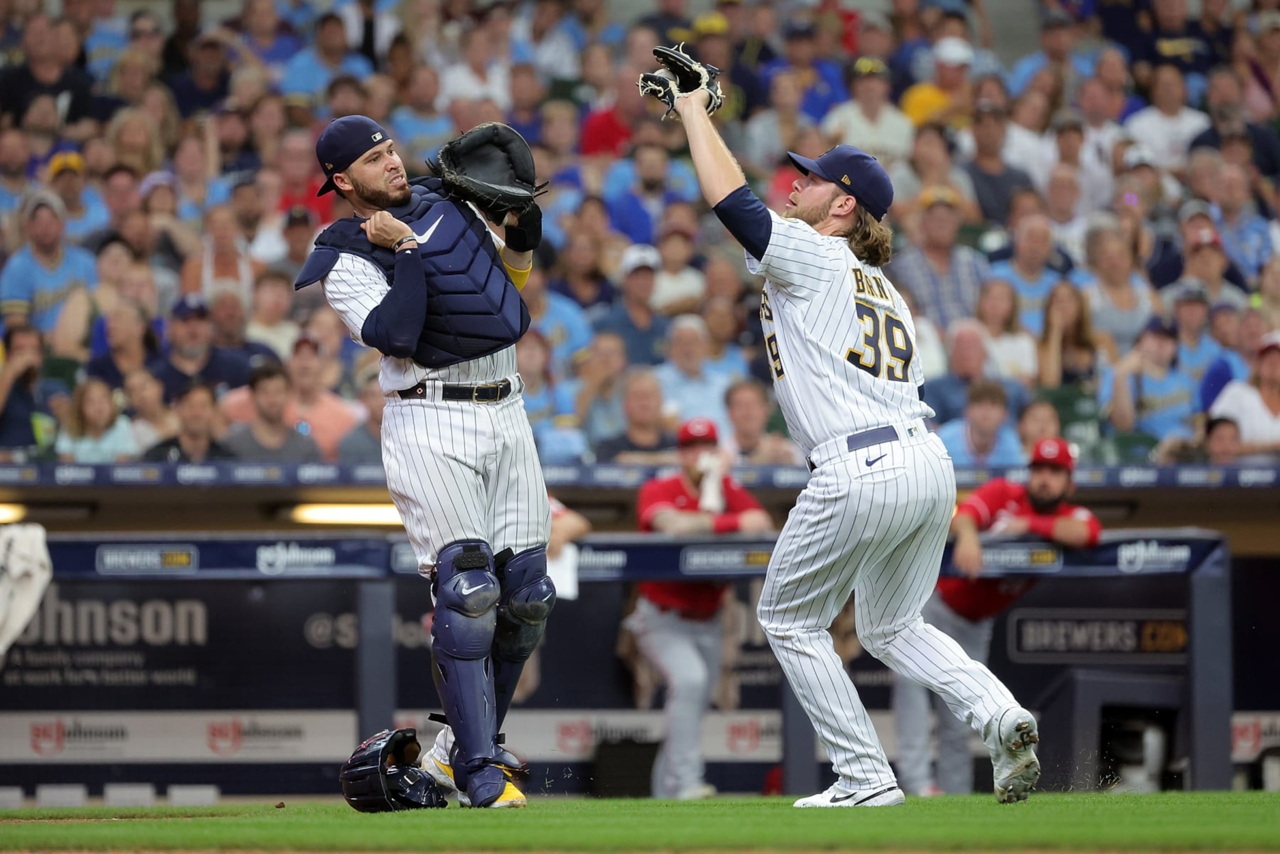 MILWAUKEE, WISCONSIN - AUGUST 07: Corbin Burnes #39 of the Milwaukee Brewers fields a fly ball in front of Victor Caratini #7 during the fifth inning against the Cincinnati Reds at American Family Field on August 07, 2022 in Milwaukee, Wisconsin. (Photo by Stacy Revere/Getty Images)