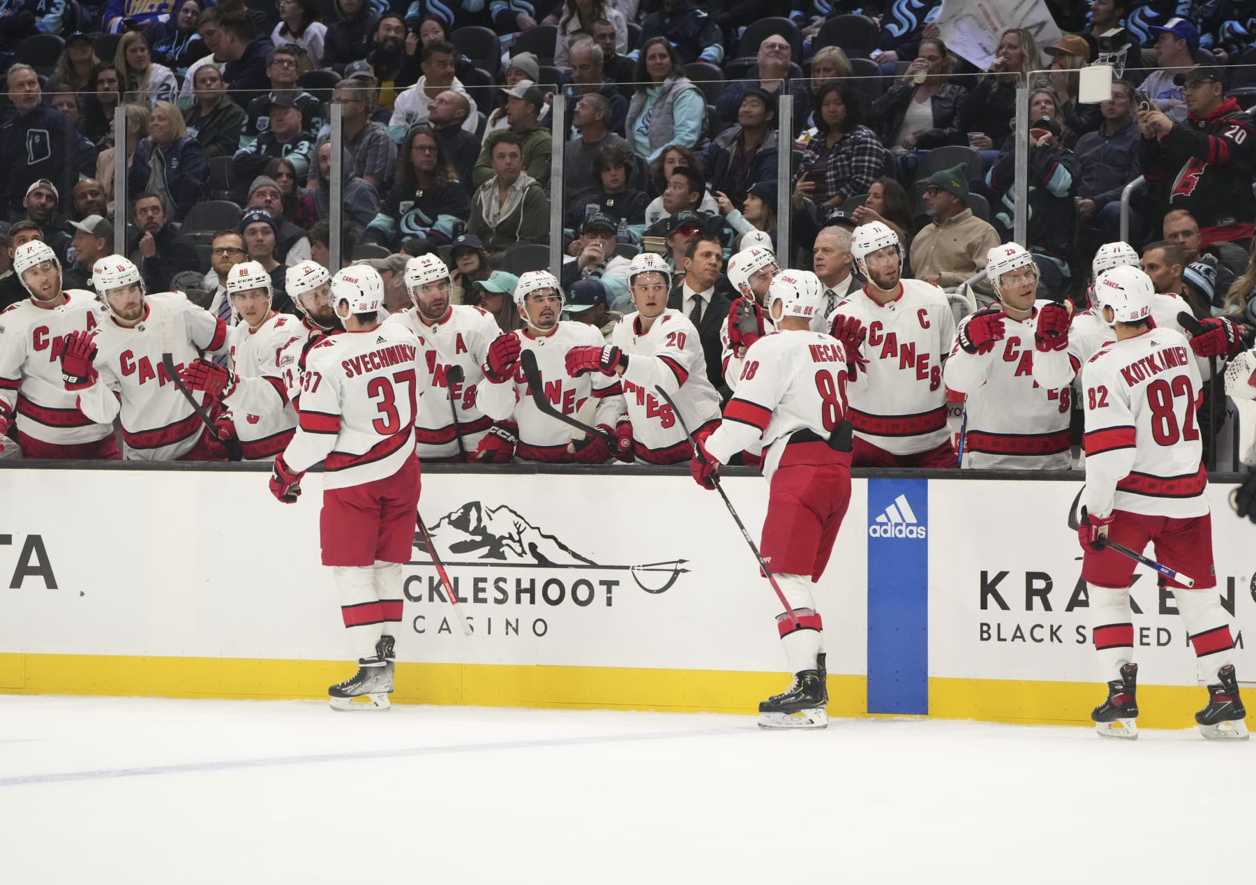 SEATTLE, WA - OCTOBER 17: Carolina Hurricanes right wing Andrei Svechnikov (37), center Derek Stepan (18) and forward Jesperi Kotkaniemi (82) celebrate a Hurricane goal with teammates during an NHL game between the Carolina Hurricanes and the Seattle Kraken on October 17, 2022 at Climate Pledge Arena in Seattle, WA. (Photo by Jeff Halstead/Icon Sportswire via Getty Images)