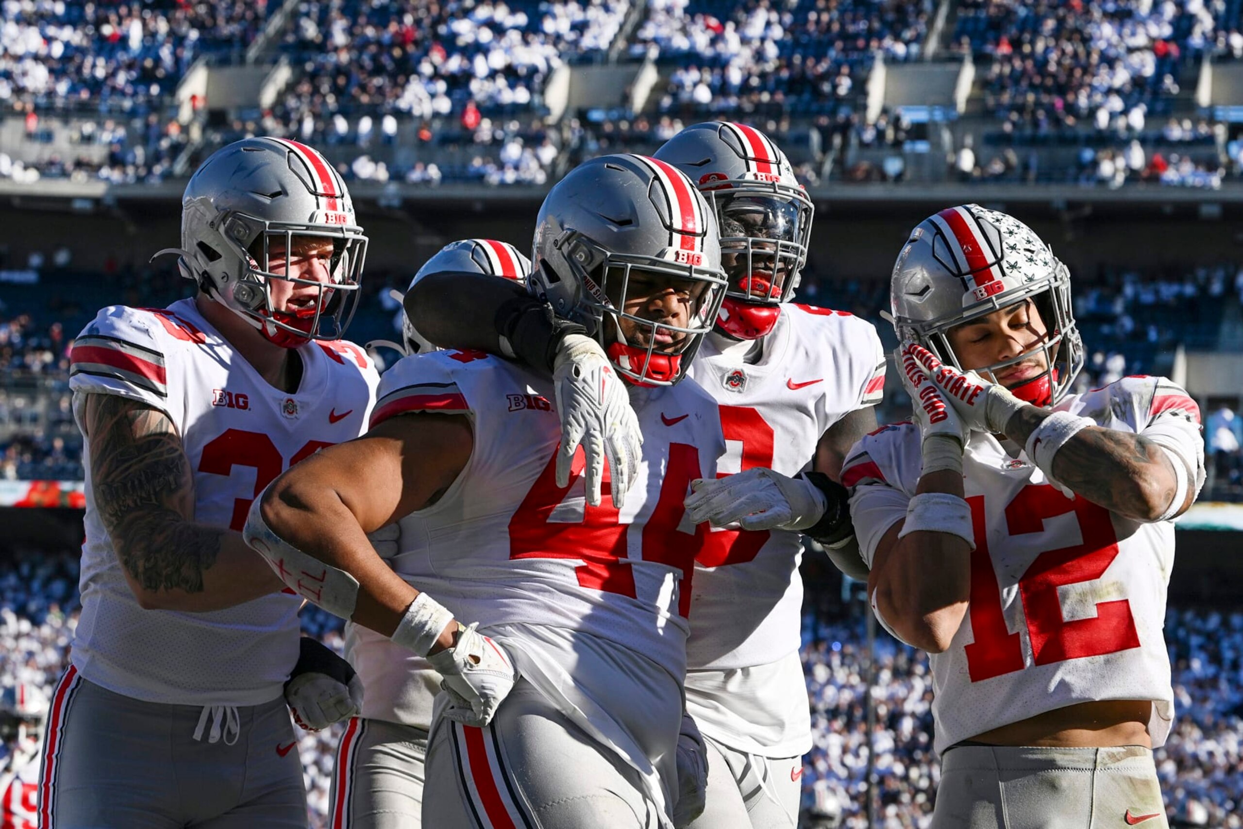 Ohio State defensive end J.T. Tuimoloau (44) celebrates with his teammates Jack Sawyer (33), Zach Harrison (9) and Lathan Ransom (12) after returning an interception for a touchdown during the fourth quarter of an NCAA college football game against Penn State, Saturday, Oct. 29, 2022, in State College, Pa. (AP Photo/Barry Reeger)