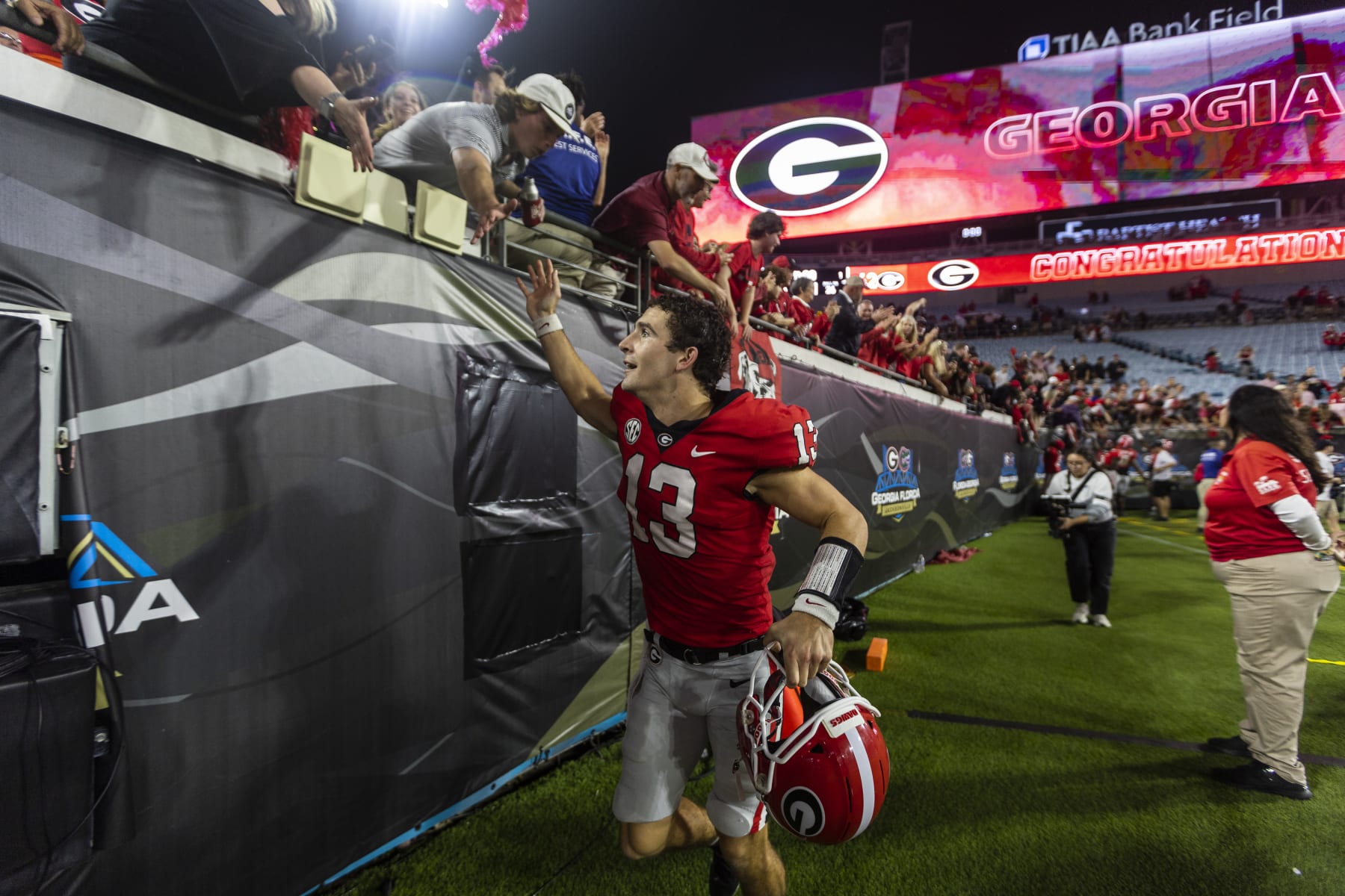 JACKSONVILLE, FLORIDA - OCTOBER 29: Stetson Bennett #13 of the Georgia Bulldogs celebrates with fans after defeating the Florida Gators 42-20 in a game at TIAA Bank Field on October 29, 2022 in Jacksonville, Florida. (Photo by James Gilbert/Getty Images)