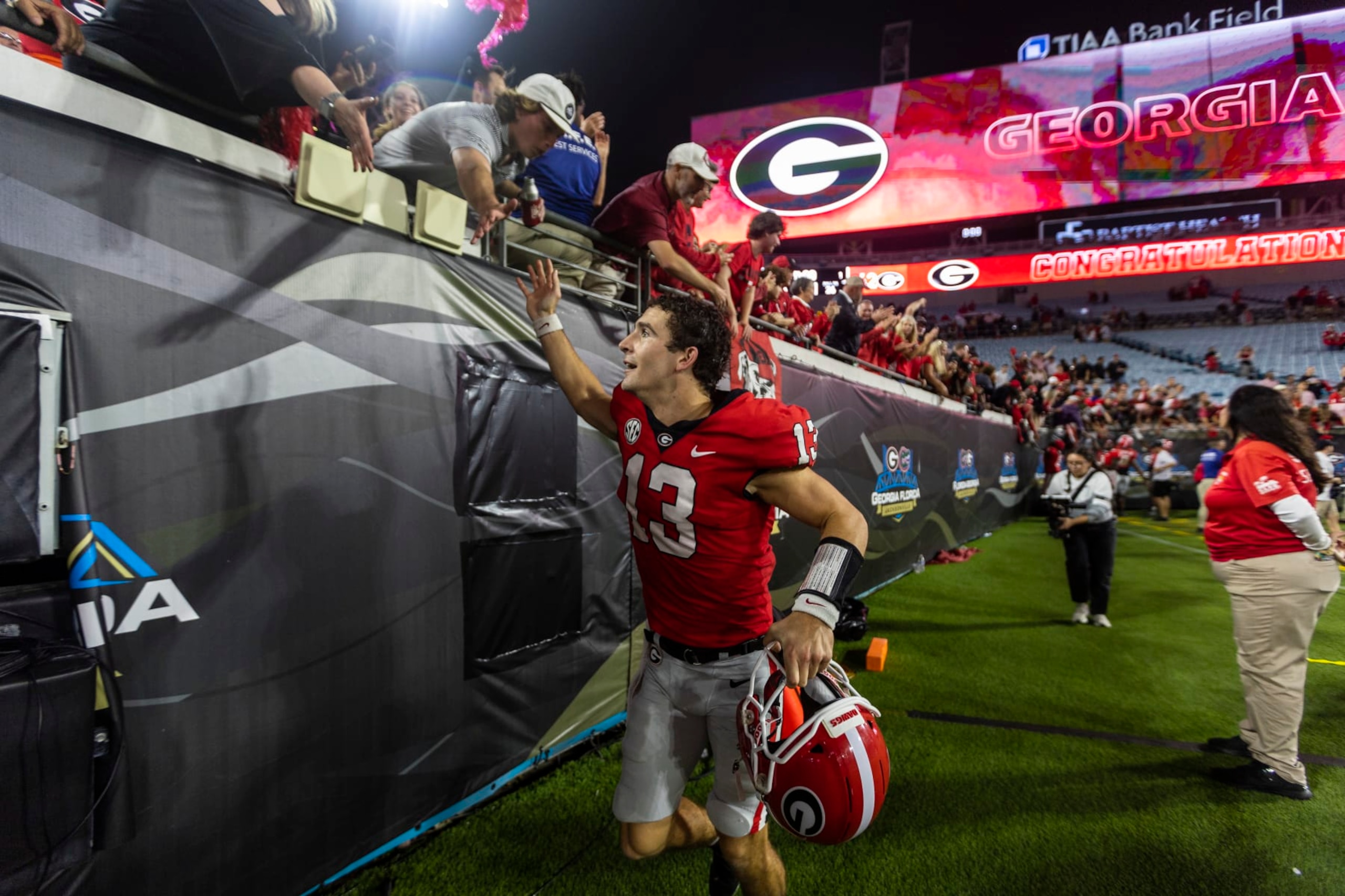 JACKSONVILLE, FLORIDA - OCTOBER 29: Stetson Bennett #13 of the Georgia Bulldogs celebrates with fans after defeating the Florida Gators 42-20 in a game at TIAA Bank Field on October 29, 2022 in Jacksonville, Florida. (Photo by James Gilbert/Getty Images)