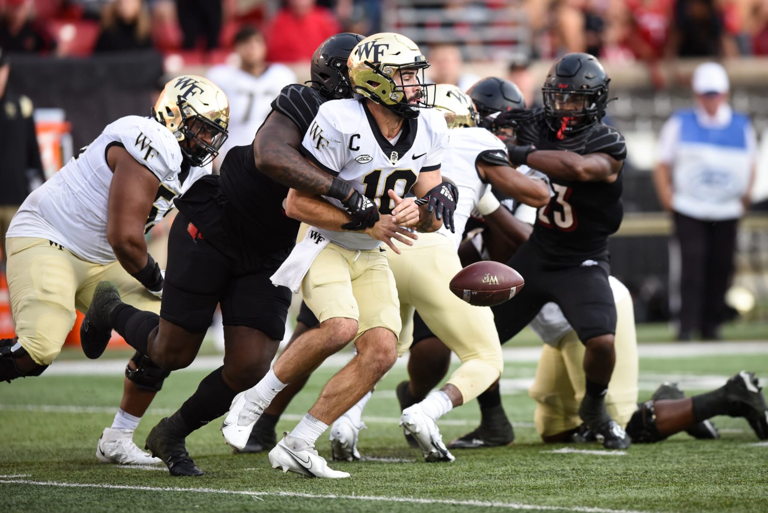 LOUISVILLE, KY - OCTOBER 29: Louisville DL Caleb Banks (54) sacks and causes Wake Forest QB Sam Hartman (10) to fumble the ball during a college football game between the Wake Forest Demon Deacons and Louisville Cardinals on October 29, 2022 at Cardinal Stadium in Louisville, Kentucky. (Photo by James Black/Icon Sportswire via Getty Images)