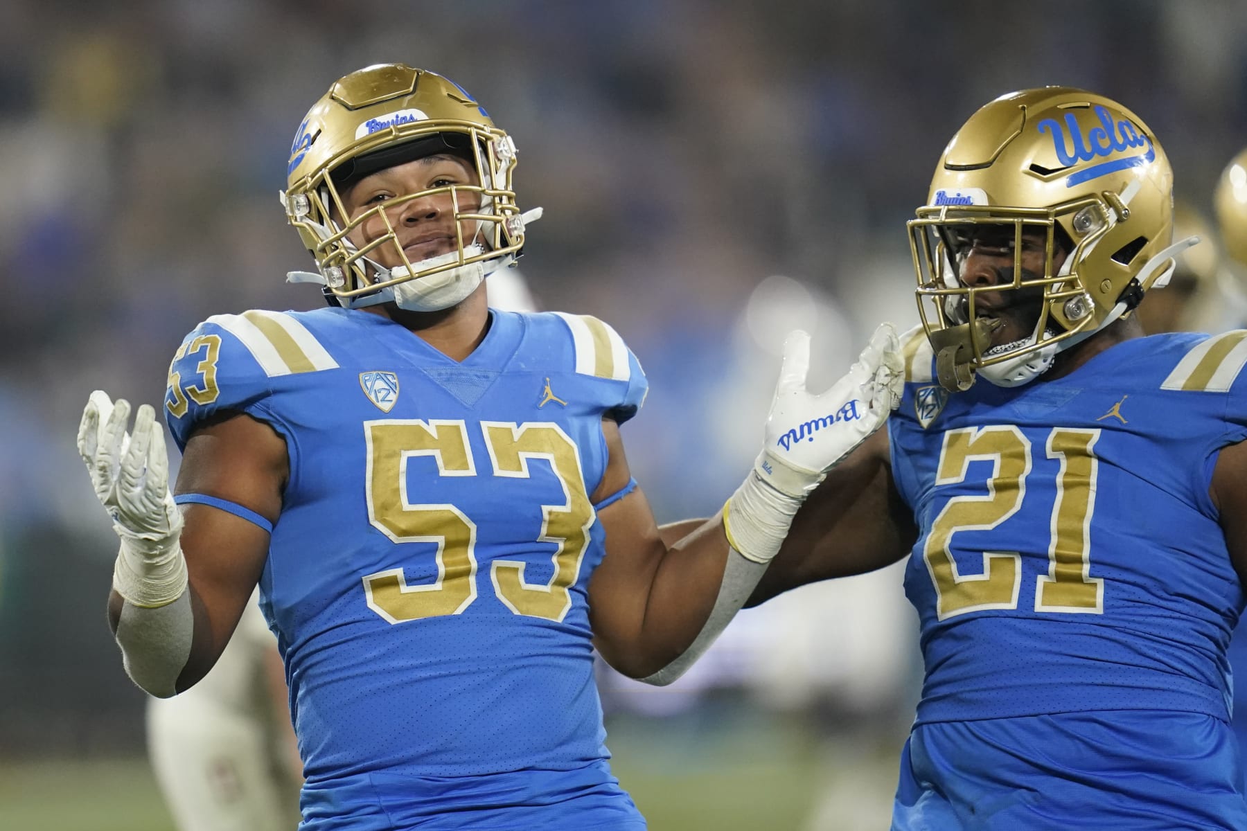 UCLA linebacker Darius Muasau (53) celebrates with linebacker JonJon Vaughns (21) after a stop during the second half of an NCAA college football game against Stanford in Pasadena, Calif., Saturday, Oct. 29, 2022. (AP Photo/Ashley Landis)