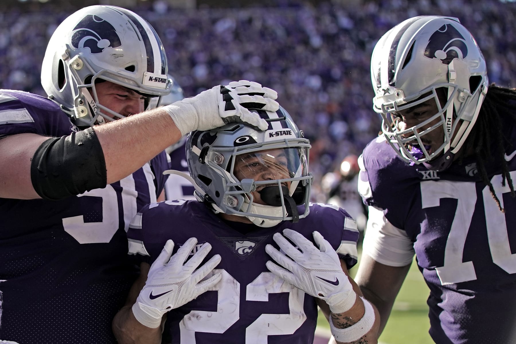 Kansas State running back Deuce Vaughn, center, celebrates with offensive linemen Cooper Beebe (50) and KT Leveston (70) after scoring a touchdown during the first half of an NCAA college football game against Oklahoma State Saturday, Oct. 29, 2022, in Manhattan, Kan. (AP Photo/Charlie Riedel)