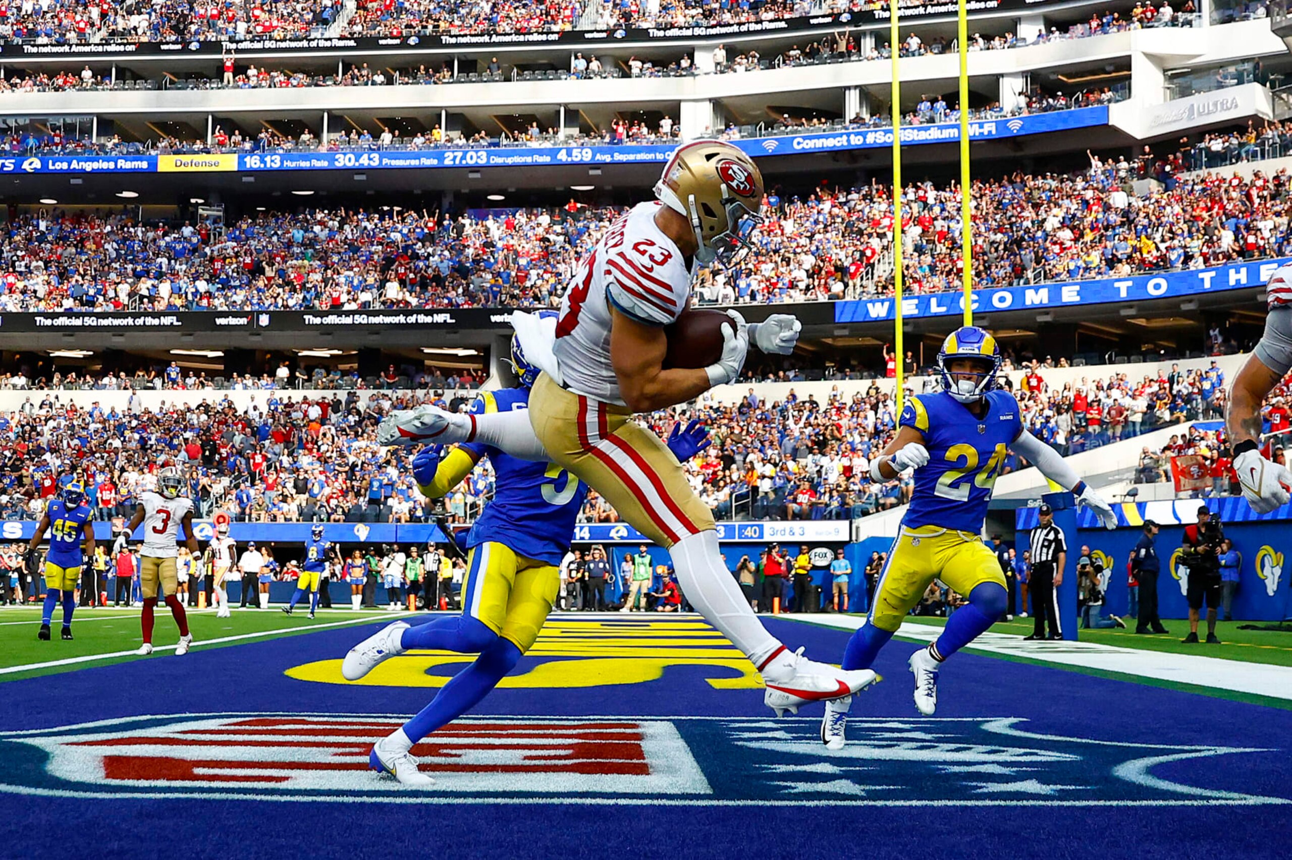 INGLEWOOD, CALIFORNIA - OCTOBER 30: Christian McCaffrey #23 of the San Francisco 49ers catches the ball for a touchdown as Jalen Ramsey #5 and Taylor Rapp #24 of the Los Angeles Rams defend during the third quarter at SoFi Stadium on October 30, 2022 in Inglewood, California. (Photo by Ronald Martinez/Getty Images)