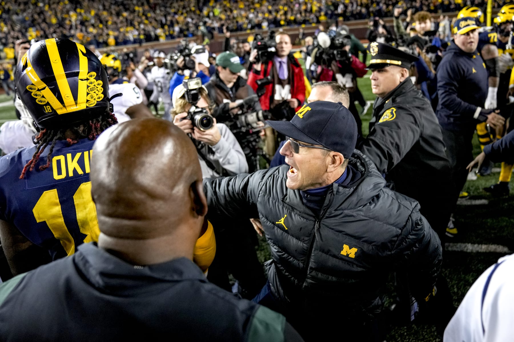ANN ARBOR, MICHIGAN - OCTOBER 29: Head coach Jim Harbaugh of the Michigan Wolverines calms down Eyabi Okie #18 of the Michigan Wolverines after defeating the Michigan State Spartans at Michigan Stadium on October 29, 2022 in Ann Arbor, Michigan. (Photo by Nic Antaya/Getty Images)