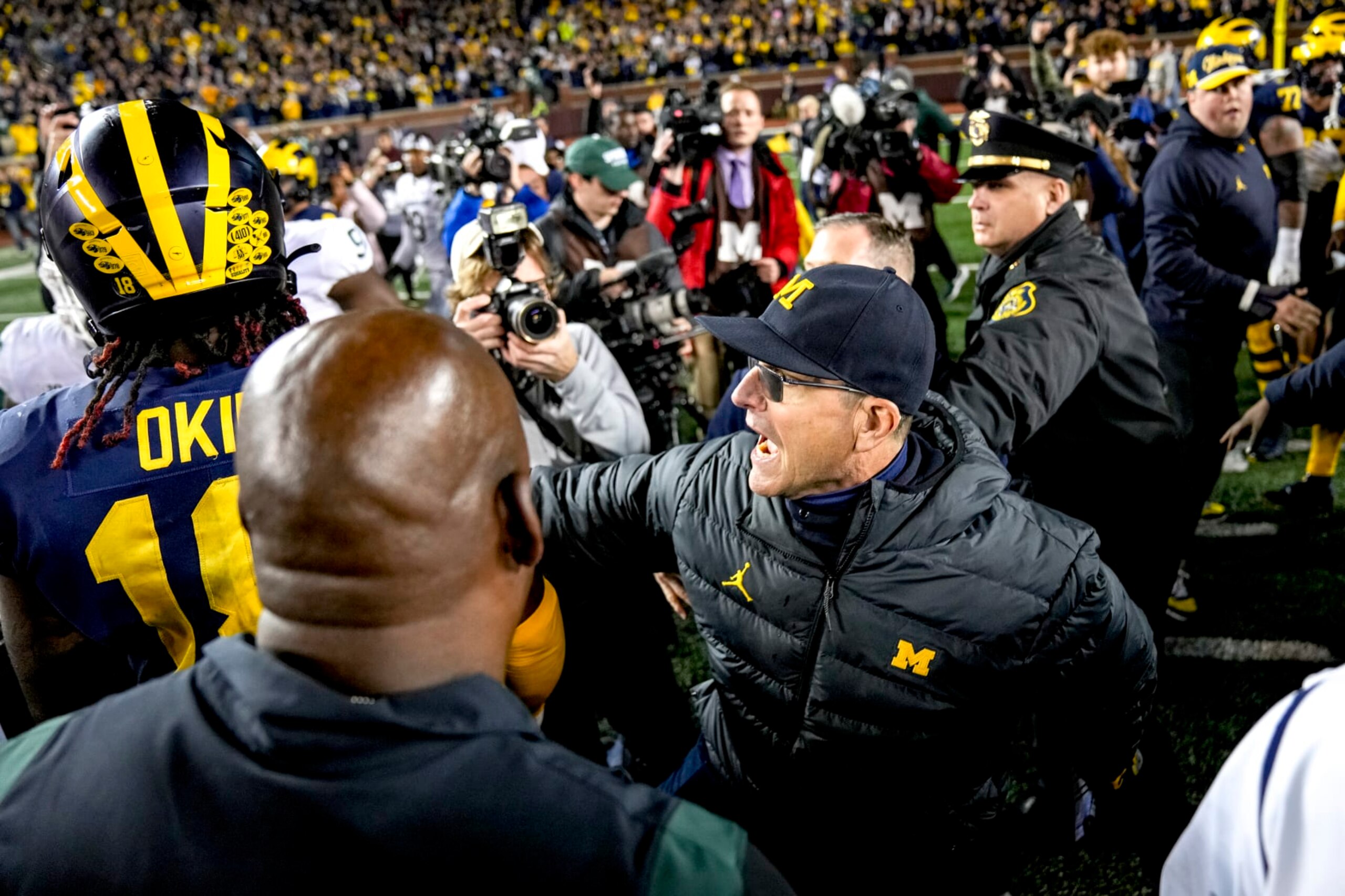ANN ARBOR, MICHIGAN - OCTOBER 29: Head coach Jim Harbaugh of the Michigan Wolverines calms down Eyabi Okie #18 of the Michigan Wolverines after defeating the Michigan State Spartans at Michigan Stadium on October 29, 2022 in Ann Arbor, Michigan. (Photo by Nic Antaya/Getty Images) ANN ARBOR, MICHIGAN - OCTOBER 29: Head coach Jim Harbaugh of the Michigan Wolverines calms down Eyabi Okie #18 of the Michigan Wolverines after defeating the Michigan State Spartans at Michigan Stadium on October 29, 2022 in Ann Arbor, Michigan. (Photo by Nic Antaya/Getty Images)