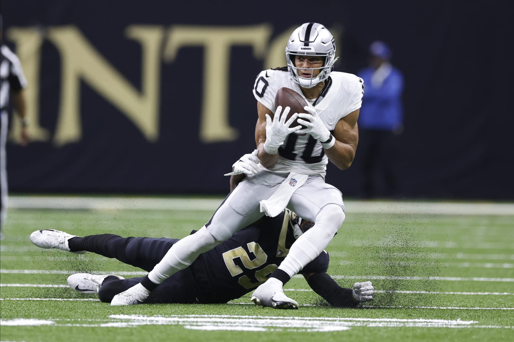 Las Vegas Raiders wide receiver Mack Hollins (10) makes a catch against New Orleans Saints cornerback Paulson Adebo (29) during the second half of an NFL football game Sunday, Oct. 30, 2022, in New Orleans. (AP Photo/Rusty Costanza)