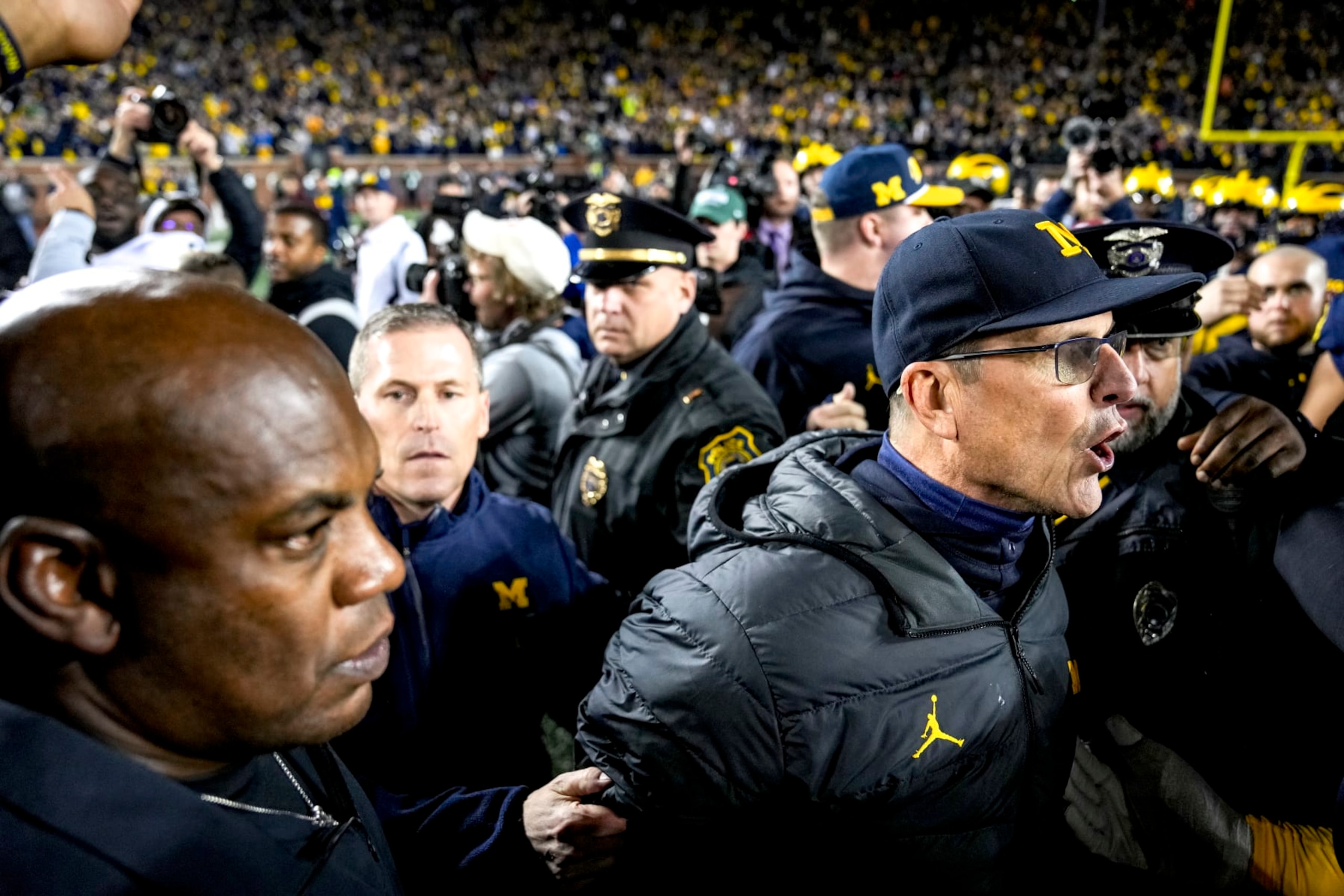 ANN ARBOR, MICHIGAN - OCTOBER 29: Head coach Jim Harbaugh of the Michigan Wolverines calms down his team after defeating the Michigan State Spartans and waiting to shake hands with head coach Mel Tucker of the Michigan State Spartans at Michigan Stadium on October 29, 2022 in Ann Arbor, Michigan. (Photo by Nic Antaya/Getty Images) ANN ARBOR, MICHIGAN - OCTOBER 29: Head coach Jim Harbaugh of the Michigan Wolverines calms down his team after defeating the Michigan State Spartans and waiting to shake hands with head coach Mel Tucker of the Michigan State Spartans at Michigan Stadium on October 29, 2022 in Ann Arbor, Michigan. (Photo by Nic Antaya/Getty Images)