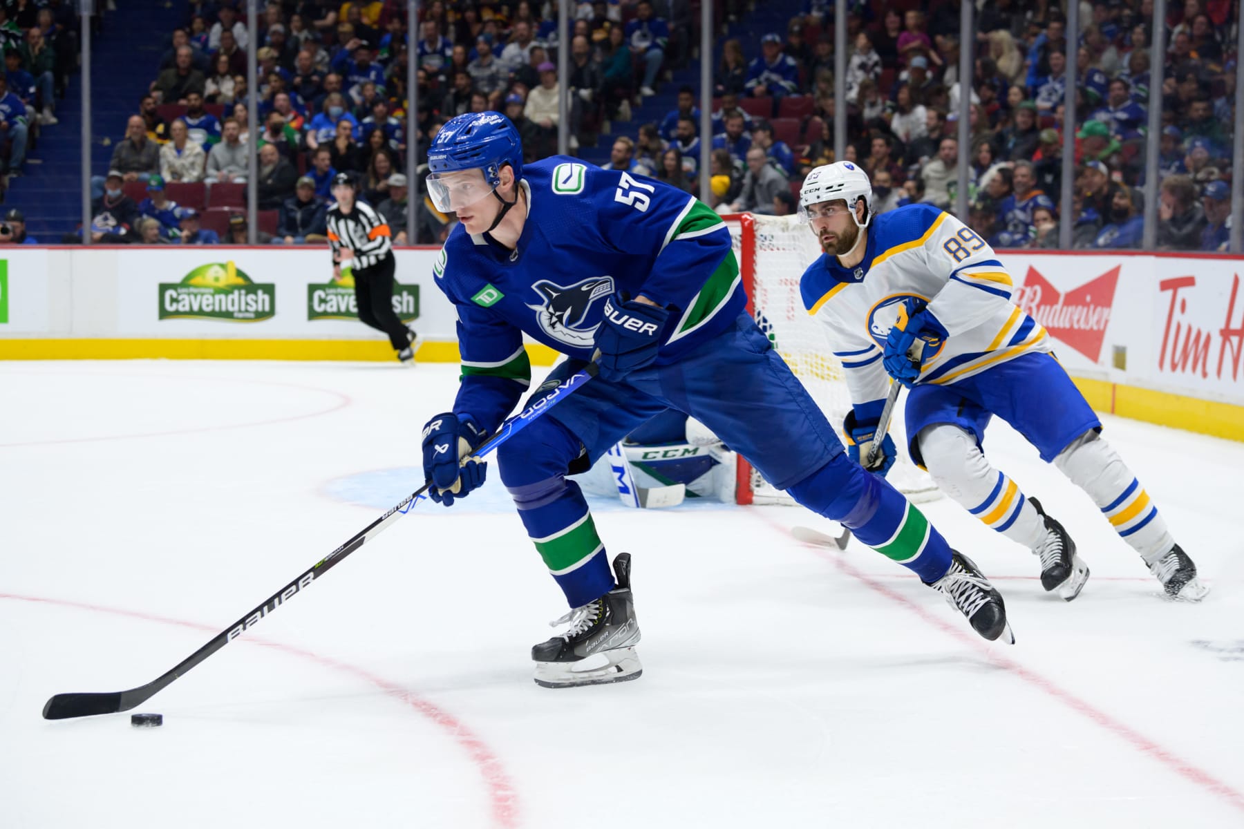 VANCOUVER, CANADA - OCTOBER 22: Tyler Myers #57 of the Vancouver Canucks is pursued by Alex Tuch #89 of the Buffalo Sabres in the third period during their NHL game at Rogers Arena October 22, 2022 in Vancouver, British Columbia, Canada.  Buffalo won 5-1. (Photo by Derek Cain/Getty Images)