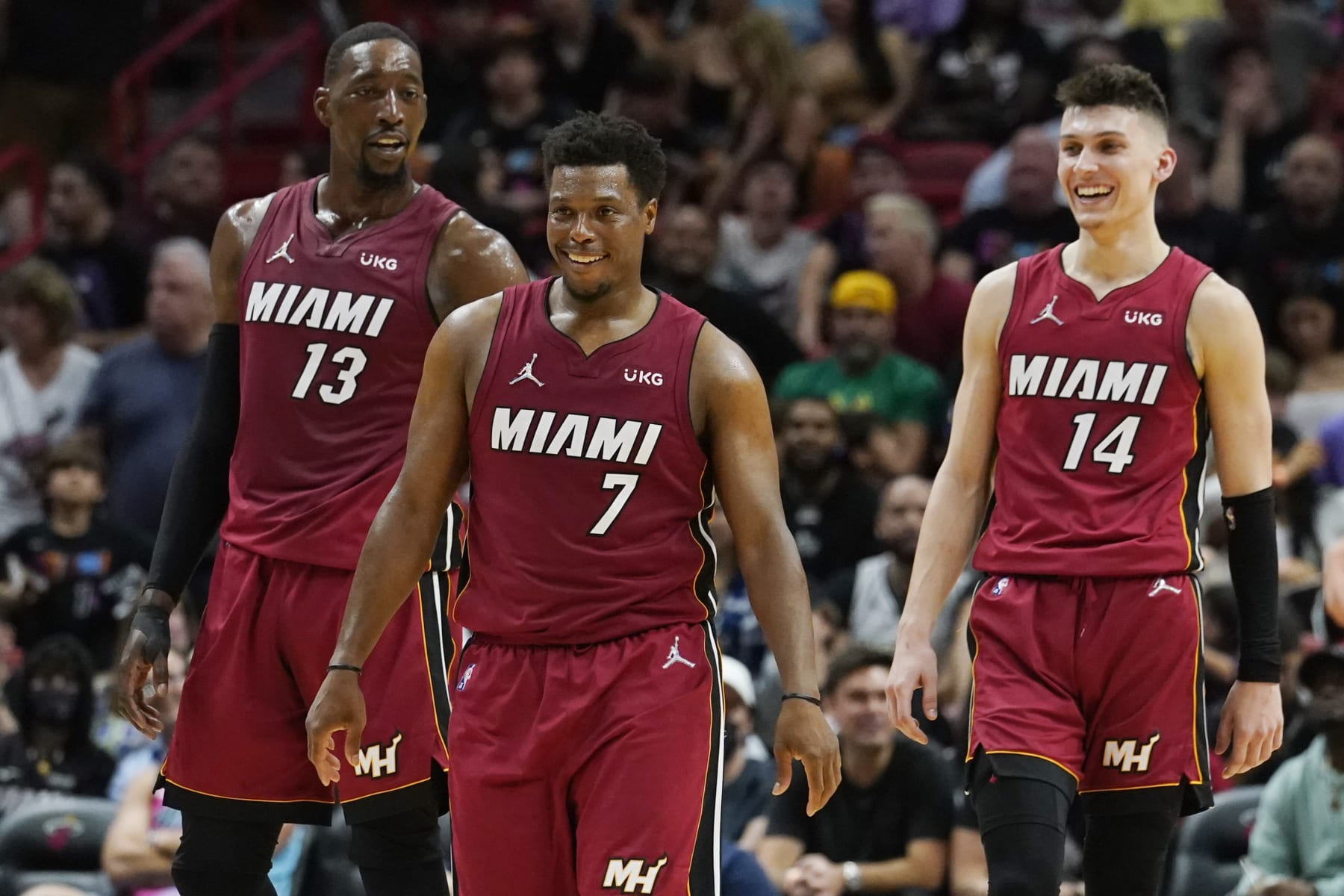 Miami Heat guard Tyler Herro (14) guard Kyle Lowry (7) and center Bam Adebayo (13) smile during the second half of an NBA basketball game against the Detroit Pistons, Tuesday, March 15, 2022, in Miami. (AP Photo/Marta Lavandier)