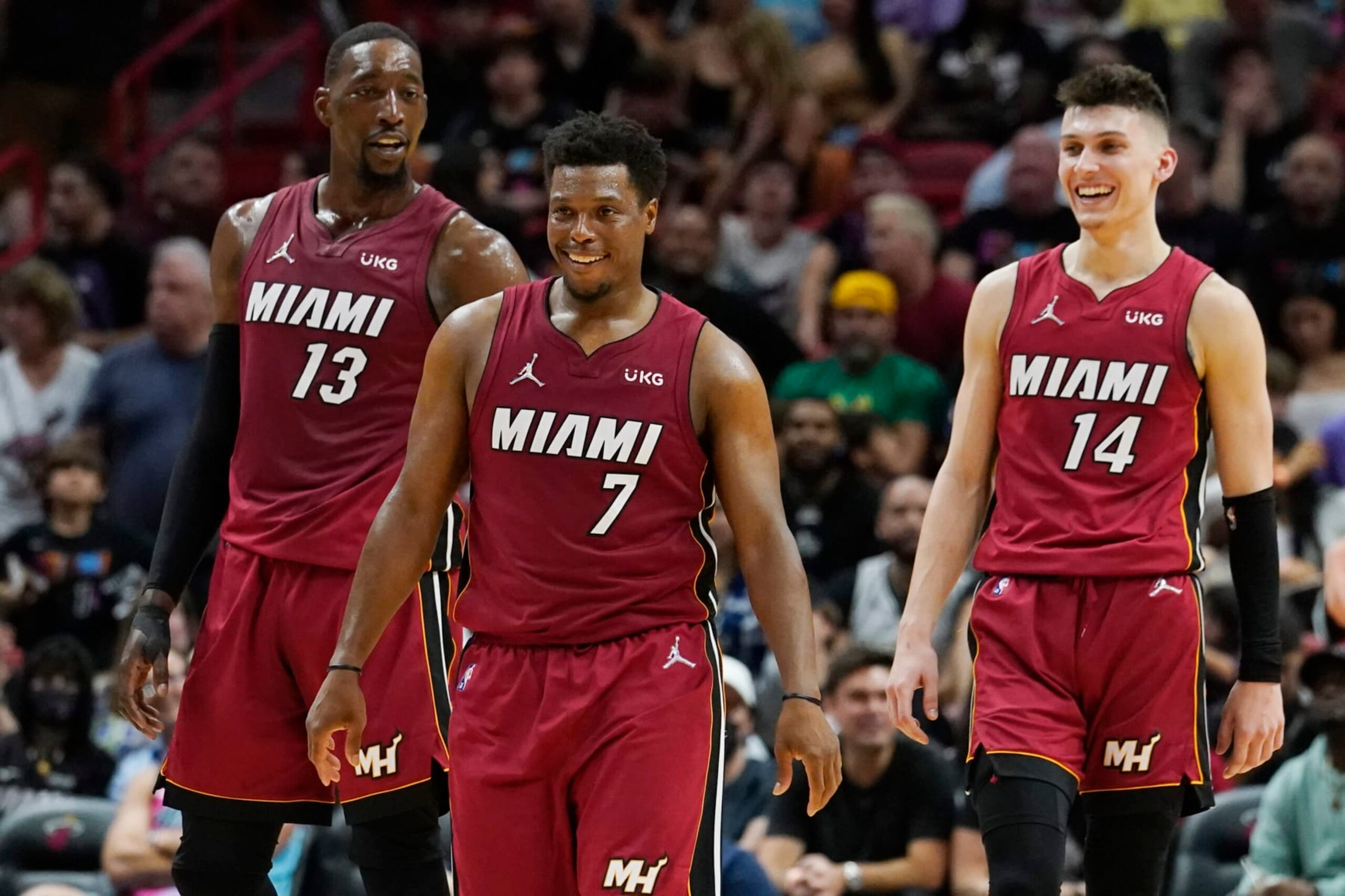 Miami Heat guard Tyler Herro (14) guard Kyle Lowry (7) and center Bam Adebayo (13) smile during the second half of an NBA basketball game against the Detroit Pistons, Tuesday, March 15, 2022, in Miami. (AP Photo/Marta Lavandier)