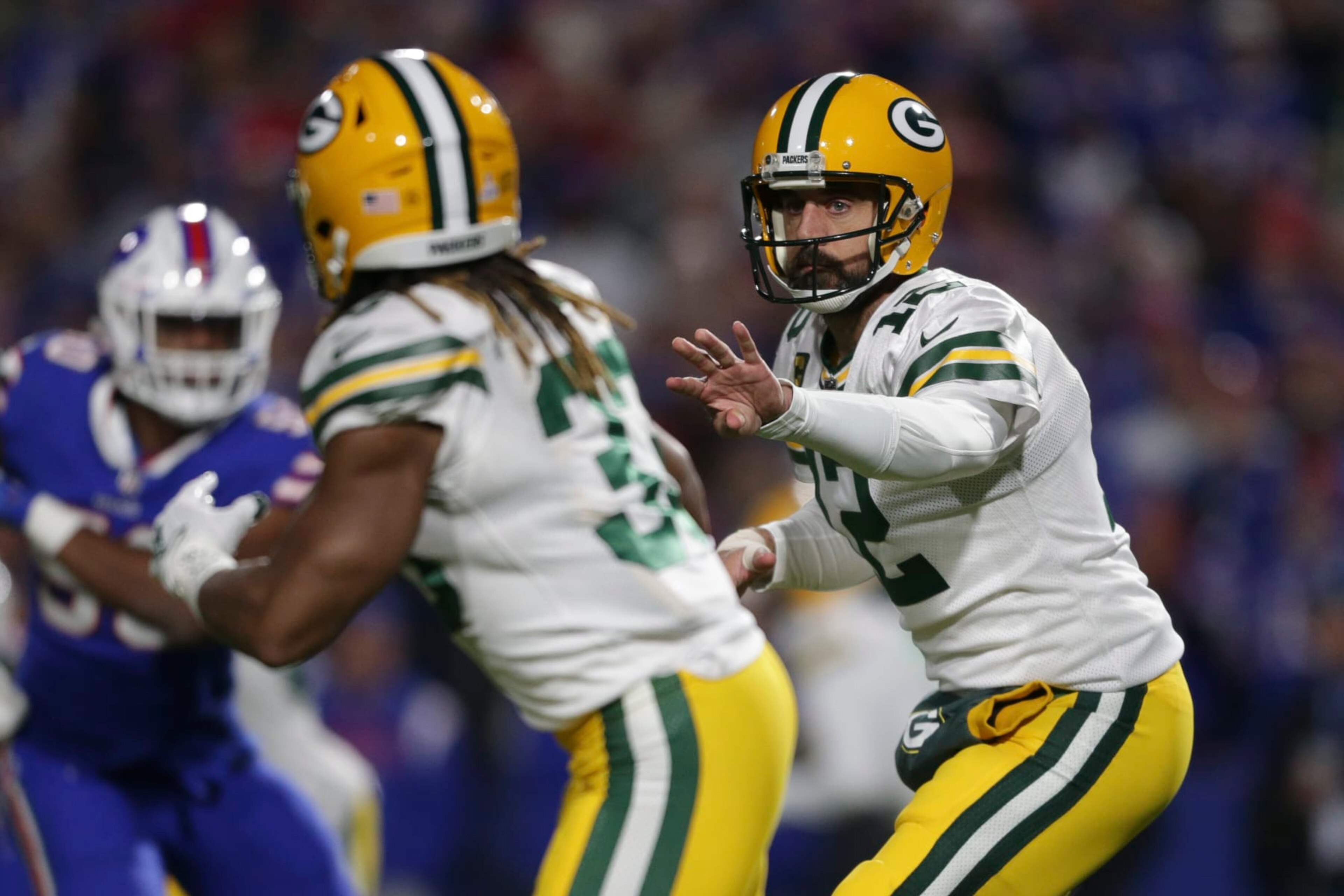 ORCHARD PARK, NEW YORK - OCTOBER 30: Aaron Rodgers #12 of the Green Bay Packers tosses the ball to Aaron Jones #33 during the first half at Highmark Stadium on October 30, 2022 in Orchard Park, New York. (Photo by Joshua Bessex/Getty Images)