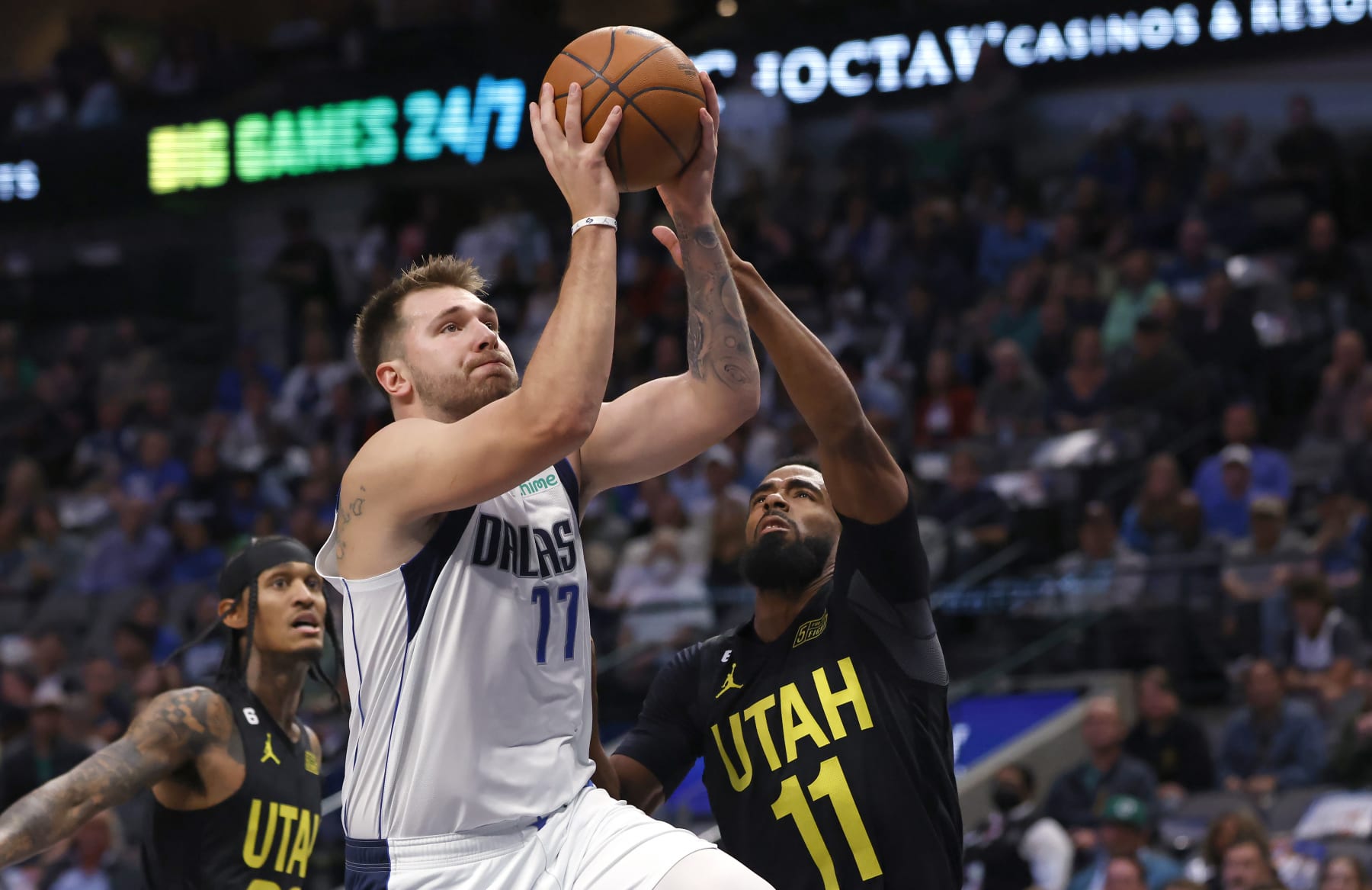 DALLAS, TX - NOVEMBER 2: Luka Doncic #77 of the Dallas Mavericks drives against Jordan Clarkson #00 and Mike Conley #11 of the Utah Jazz in the first half at American Airlines Center on November 2, 2022 in Dallas, Texas. NOTE TO USER: User expressly acknowledges and agrees that, by downloading and or using this photograph, User is consenting to the terms and conditions of the Getty Images License Agreement. (Photo by Ron Jenkins/Getty Images)
