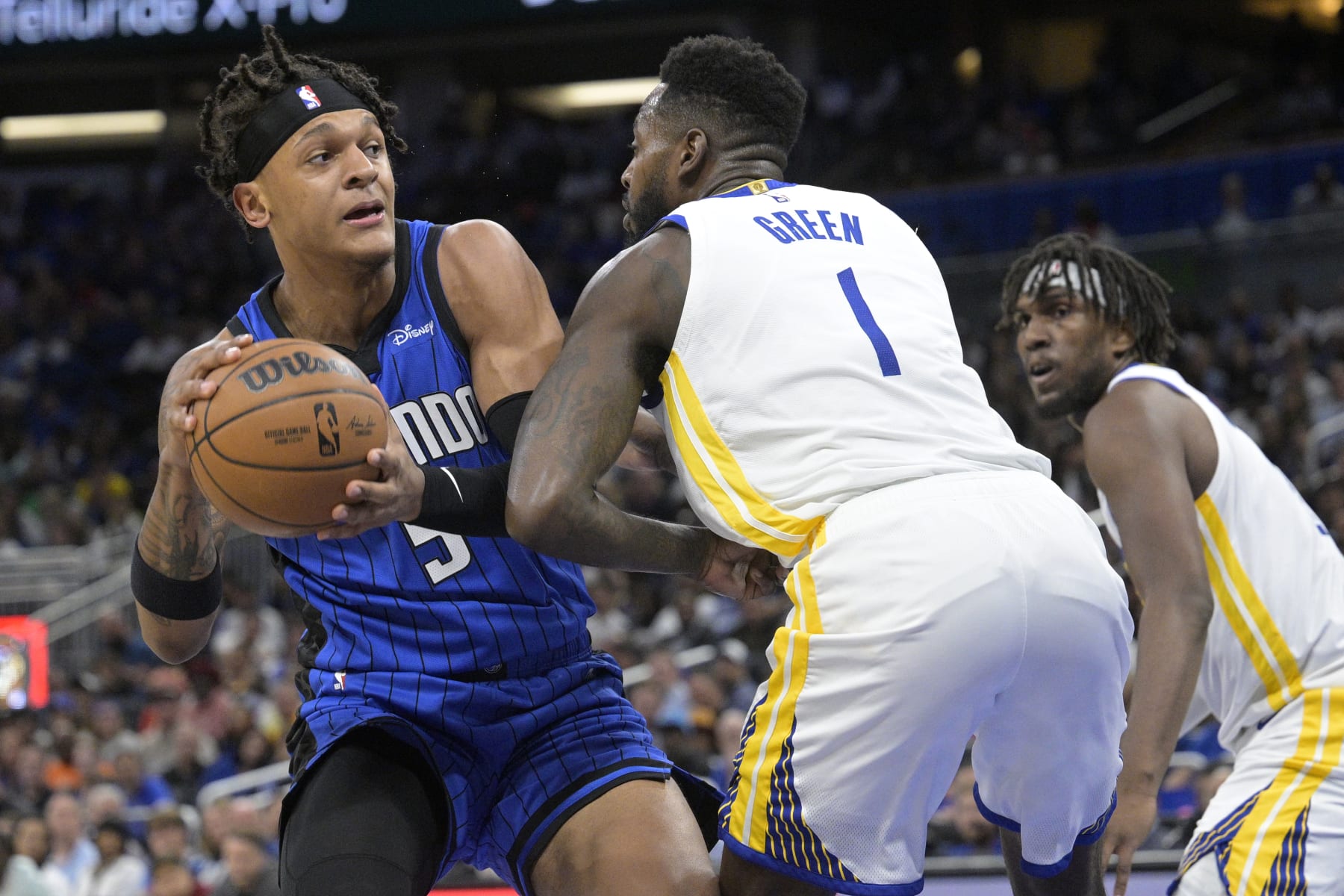 Orlando Magic forward Paolo Banchero (5) is defended by Golden State Warriors forward JaMychal Green (1) during the first half of an NBA basketball game Thursday, Nov. 3, 2022, in Orlando, Fla. (AP Photo/Phelan M. Ebenhack)