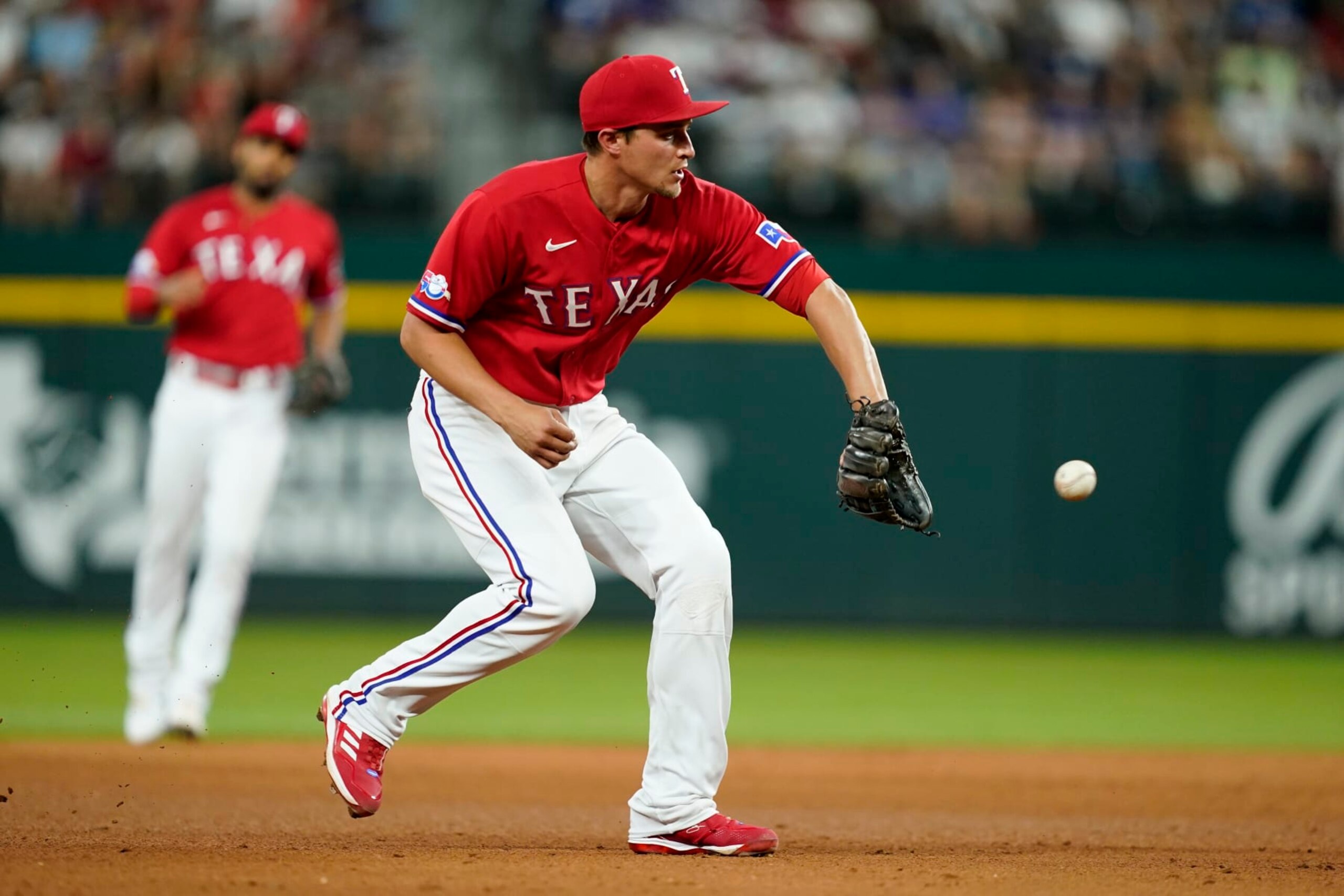 Texas Rangers shortstop Corey Seager reaches out to field a ground out by Washington Nationals' Victor Robles in the fifth inning of a baseball game, Friday, June 24, 2022, in Arlington, Texas. (AP Photo/Tony Gutierrez)