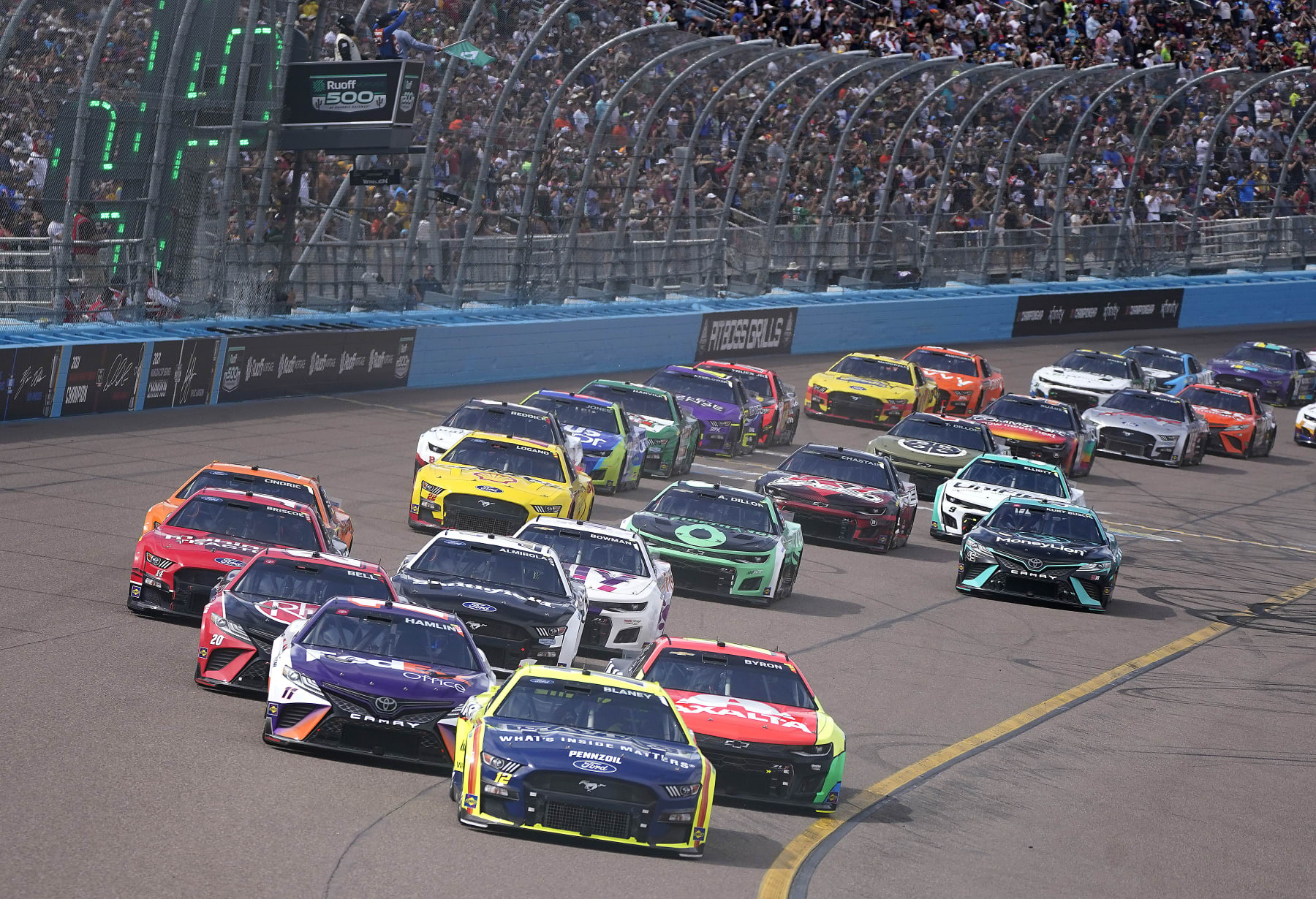 Cars take Turn 4 to start the first lap of a NASCAR Cup Series auto race at Phoenix Raceway, Sunday, March 13, 2022, in Avondale, Ariz. (AP Photo/Darryl Webb)
