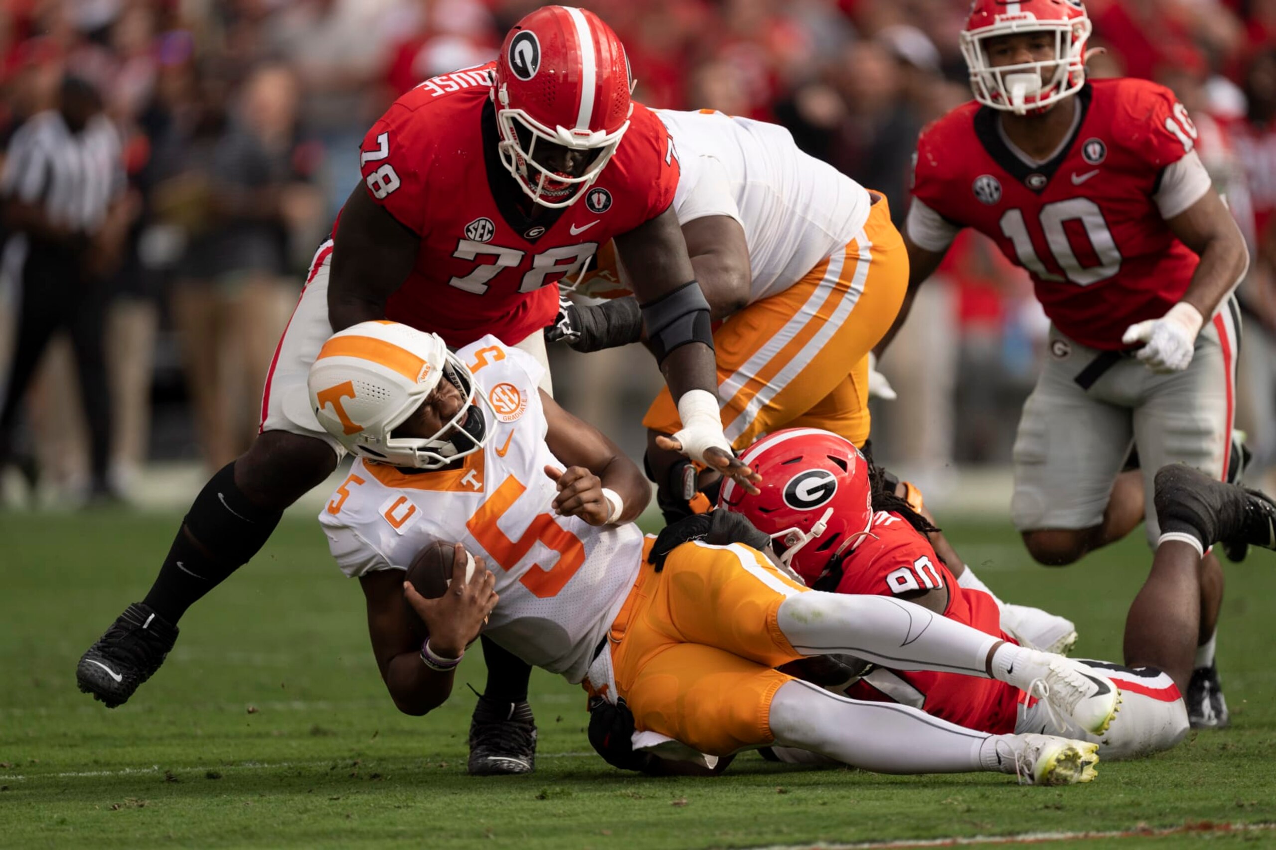 Tennessee quarterback Hendon Hooker (5) is sacked by Georgia defensive linemen Tramel Walthour (90) and Nazir Stackhouse (78) during the first half of an NCAA college football game Saturday, Nov. 5, 2022 in Athens, Ga. (AP Photo/John Bazemore) Tennessee quarterback Hendon Hooker (5) is sacked by Georgia defensive linemen Tramel Walthour (90) and Nazir Stackhouse (78) during the first half of an NCAA college football game Saturday, Nov. 5, 2022 in Athens, Ga. (AP Photo/John Bazemore)