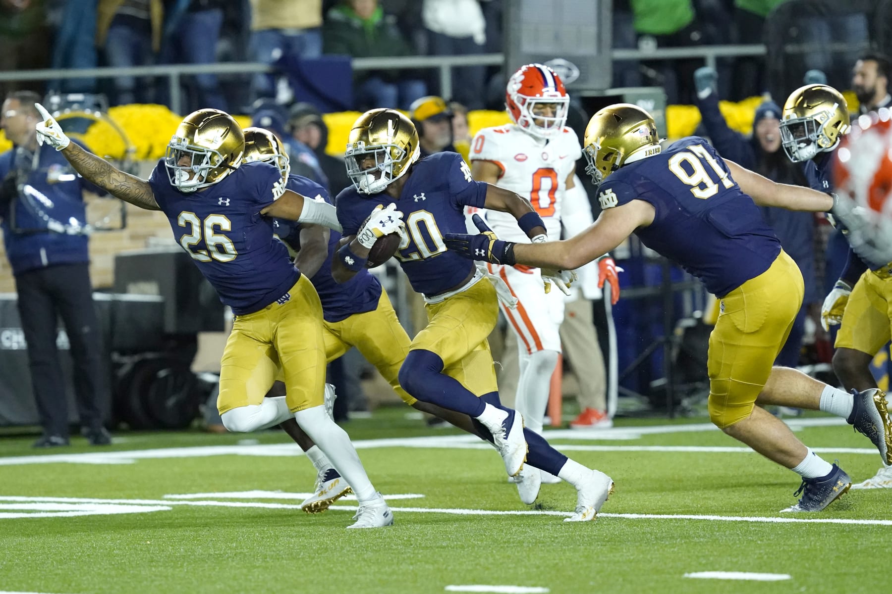 Notre Dame cornerback Benjamin Morrison (20) begins to celebrate with teammates Xavier Watts (26) and Gabriel Rubio after Morrison's interception of a pass by Clemson quarterback Cade Klubnik during the second half of an NCAA college football game Saturday, Nov. 5, 2022, in South Bend, Ind. Notre Dame won 35-14. (AP Photo/Charles Rex Arbogast)