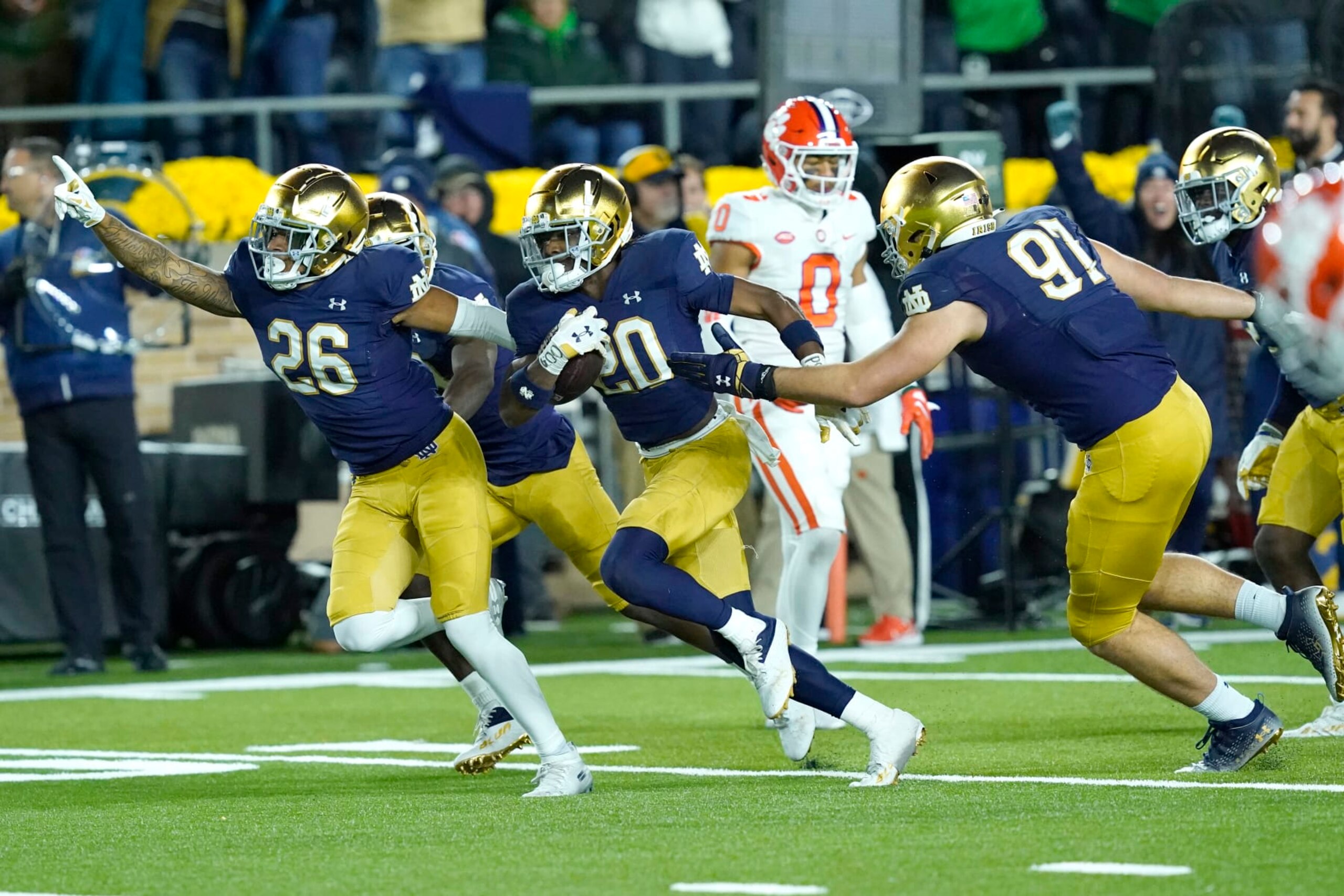 Notre Dame cornerback Benjamin Morrison (20) begins to celebrate with teammates Xavier Watts (26) and Gabriel Rubio after Morrison's interception of a pass by Clemson quarterback Cade Klubnik during the second half of an NCAA college football game Saturday, Nov. 5, 2022, in South Bend, Ind. Notre Dame won 35-14. (AP Photo/Charles Rex Arbogast)