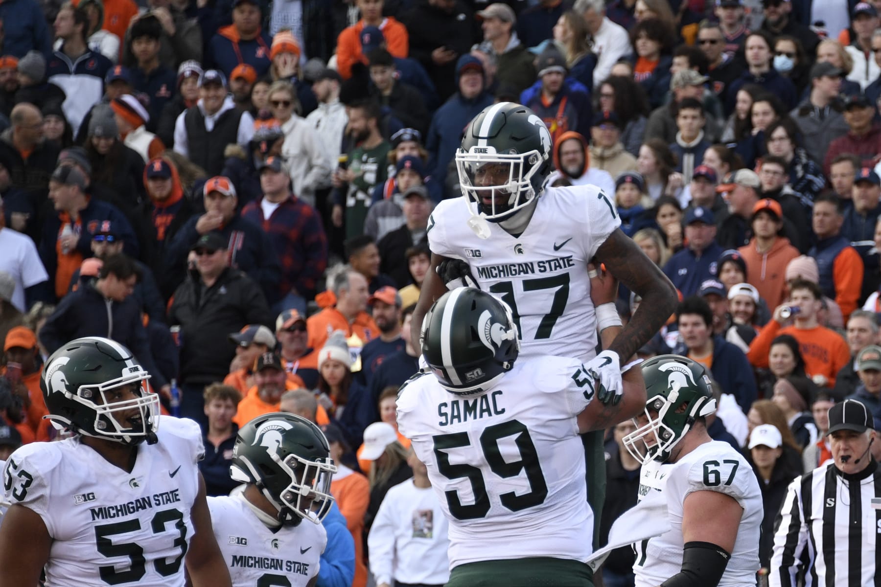 Michigan State wide receiver Tre Mosley (17) celebrates with center Nick Samac (59) after he scored a touchdown against Illinois during the first half of an NCAA college football game, Saturday, Nov. 5, 2022, in Champaign, Ill. (AP Photo/Matt Marton)