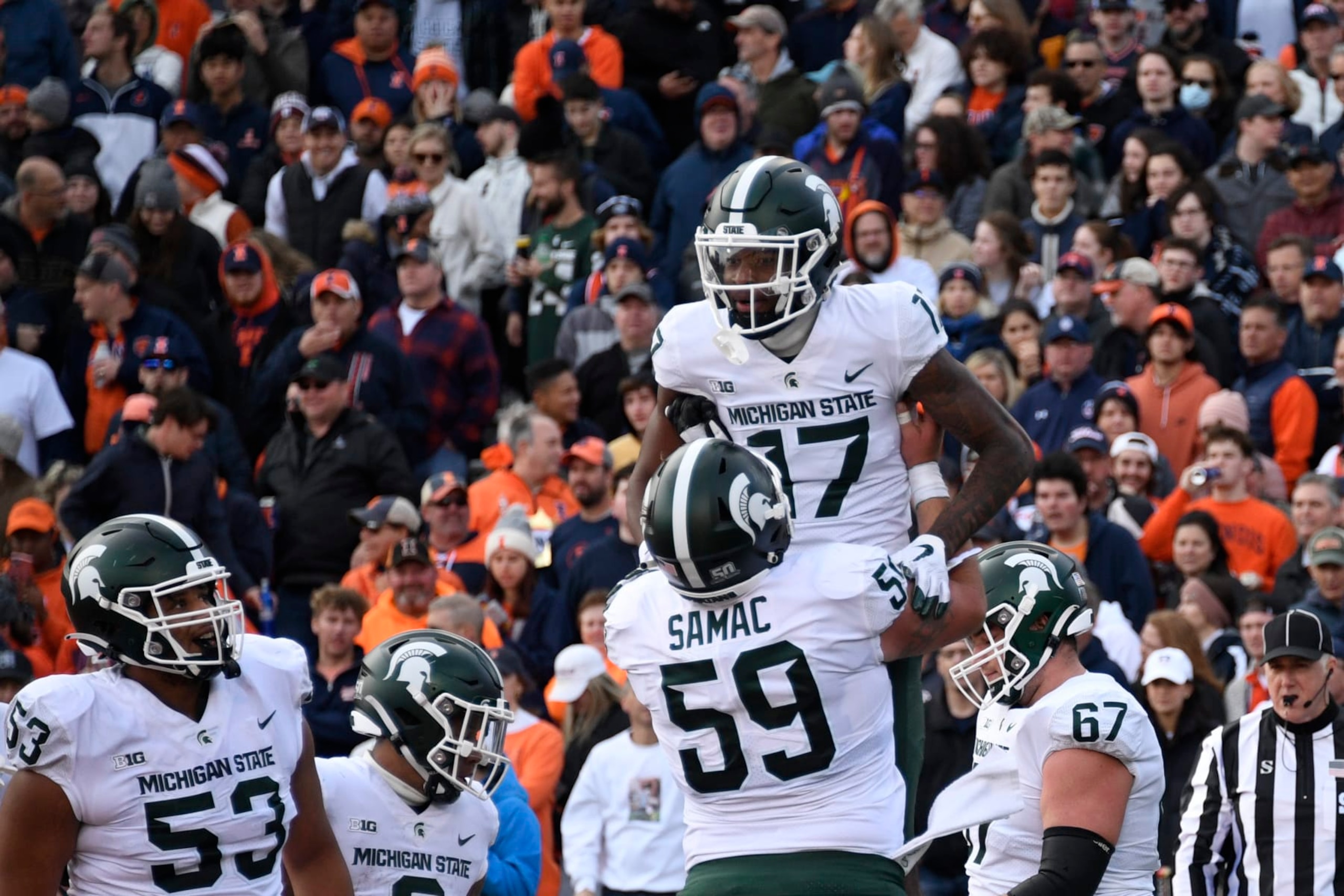 Michigan State wide receiver Tre Mosley (17) celebrates with center Nick Samac (59) after he scored a touchdown against Illinois during the first half of an NCAA college football game, Saturday, Nov. 5, 2022, in Champaign, Ill. (AP Photo/Matt Marton)