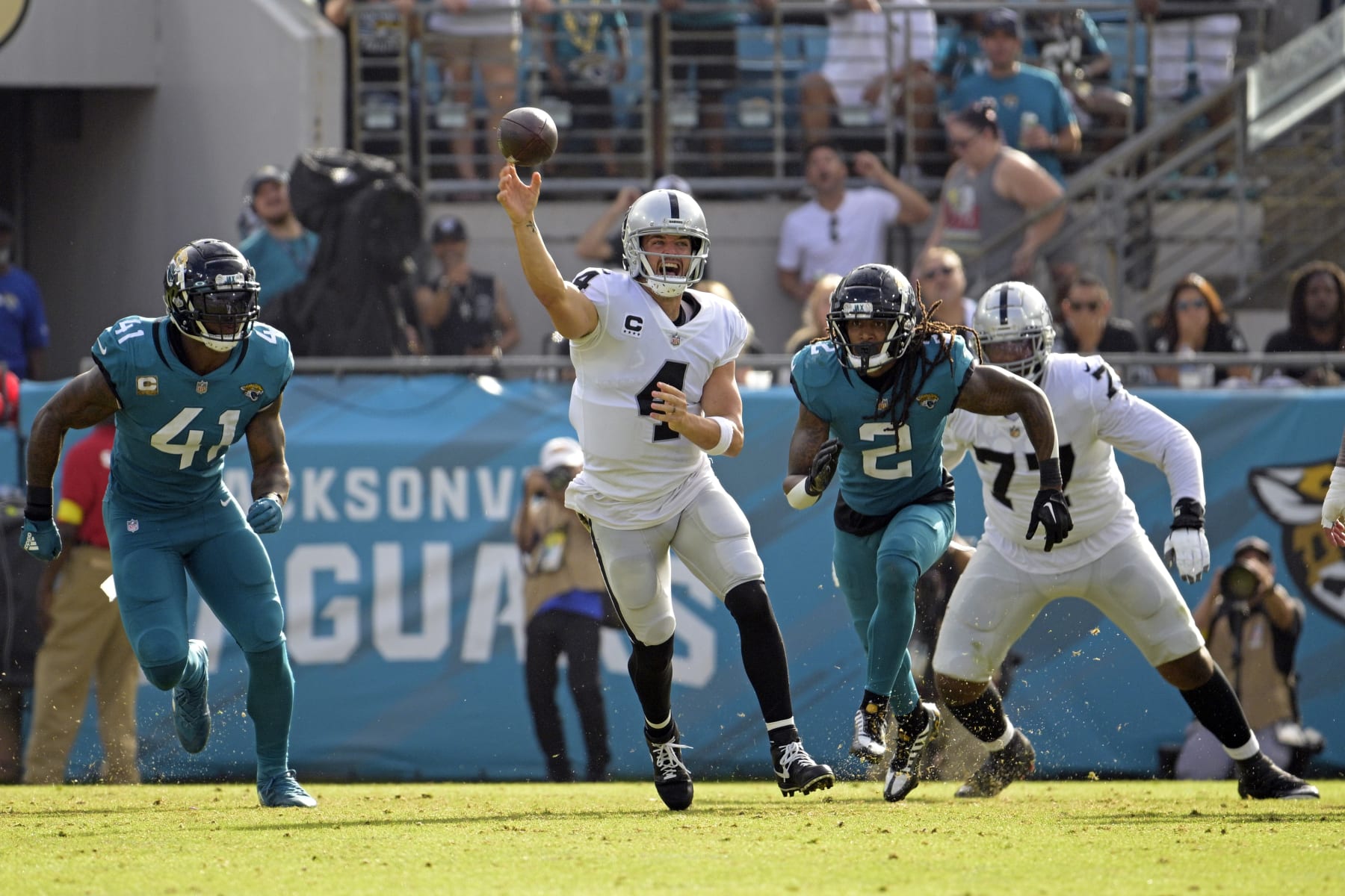 Las Vegas Raiders quarterback Derek Carr (4) passes as he is pressured by Jacksonville Jaguars linebacker Josh Allen (41) and safety Rayshawn Jenkins (2) in the second half of an NFL football game Sunday, Nov. 6, 2022, in Jacksonville, Fla. (AP Photo/Phelan M. Ebenhack)