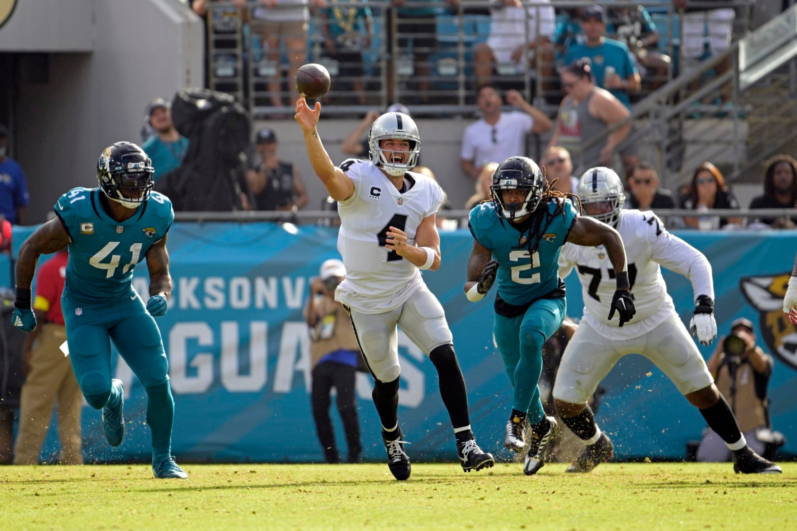 Las Vegas Raiders quarterback Derek Carr (4) passes as he is pressured by Jacksonville Jaguars linebacker Josh Allen (41) and safety Rayshawn Jenkins (2) in the second half of an NFL football game Sunday, Nov. 6, 2022, in Jacksonville, Fla. (AP Photo/Phelan M. Ebenhack)