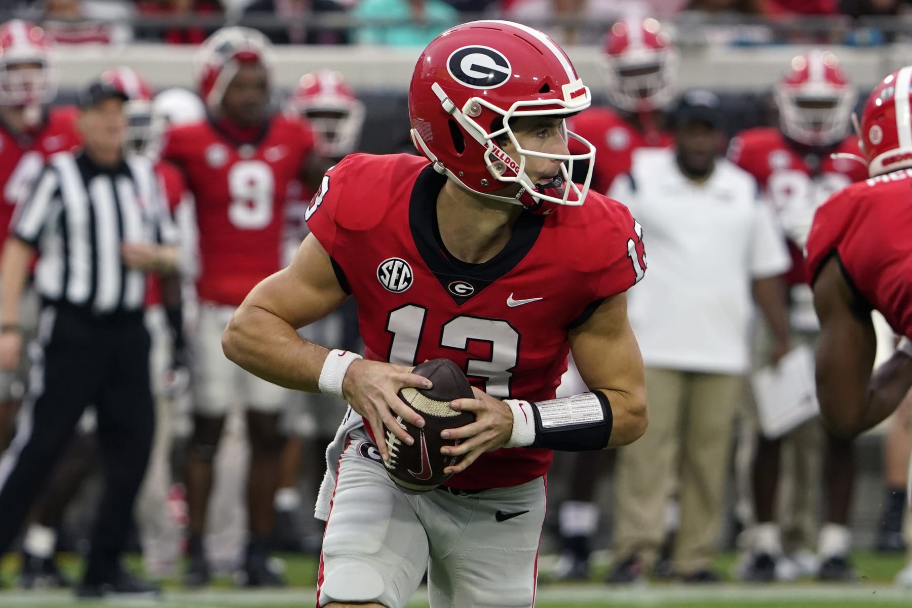 Georgia quarterback Stetson Bennett (13) scrambles as he looks for a receiver against Florida during the first half of an NCAA college football game, Saturday, Oct. 29, 2022, in Jacksonville, Fla. (AP Photo/John Raoux)