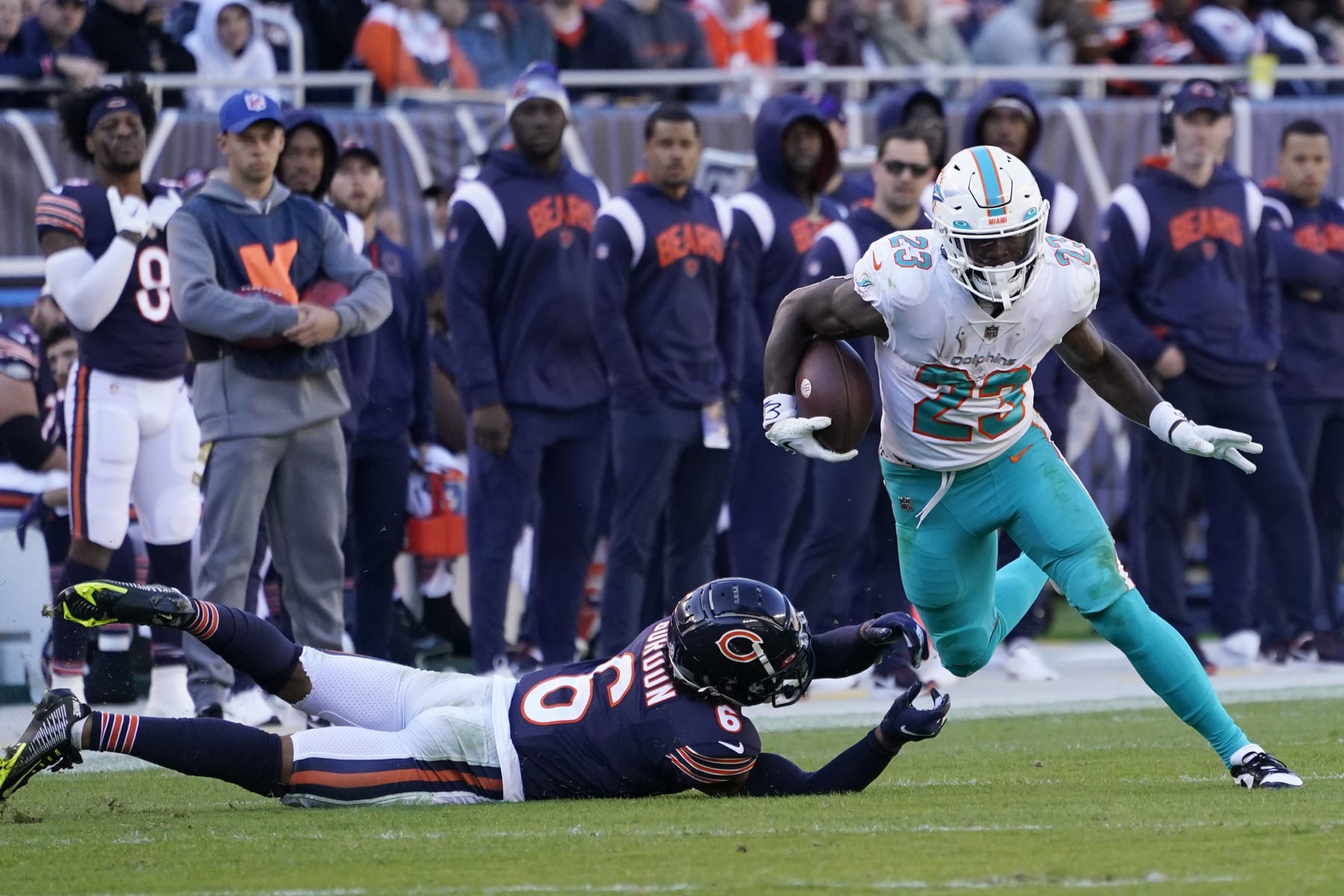 Miami Dolphins running back Jeff Wilson Jr. (23) avoids a tackle by Chicago Bears defensive back Kyler Gordon (6) during the second half of an NFL football game, Sunday, Nov. 6, 2022 in Chicago. (AP Photo/Charles Rex Arbogast)