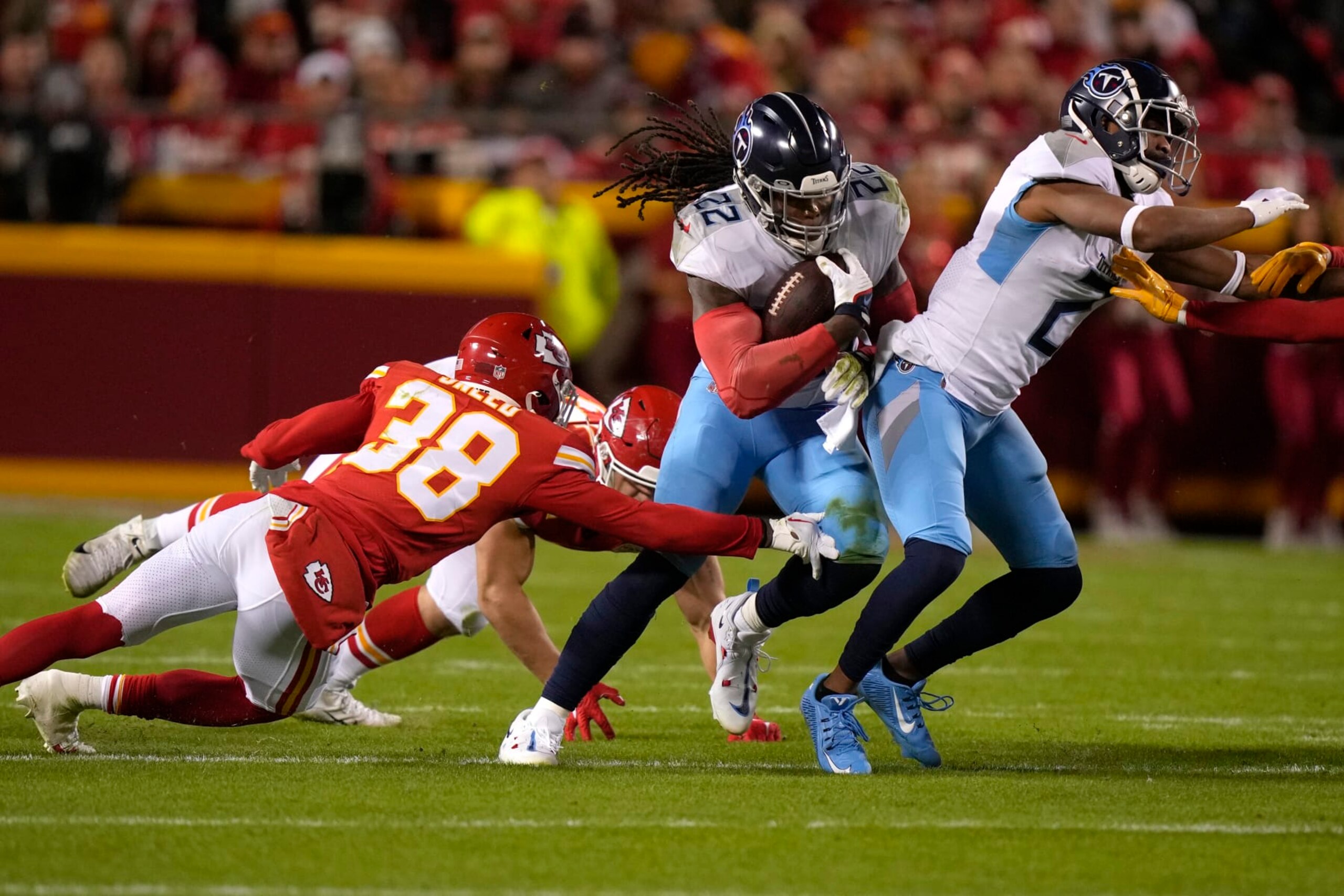 Tennessee Titans running back Derrick Henry (22) runs with the ball ;past Kansas City Chiefs cornerback L'Jarius Sneed (38) during the first half of an NFL football game Sunday, Nov. 6, 2022, in Kansas City, Mo. (AP Photo/Charlie Riedel)