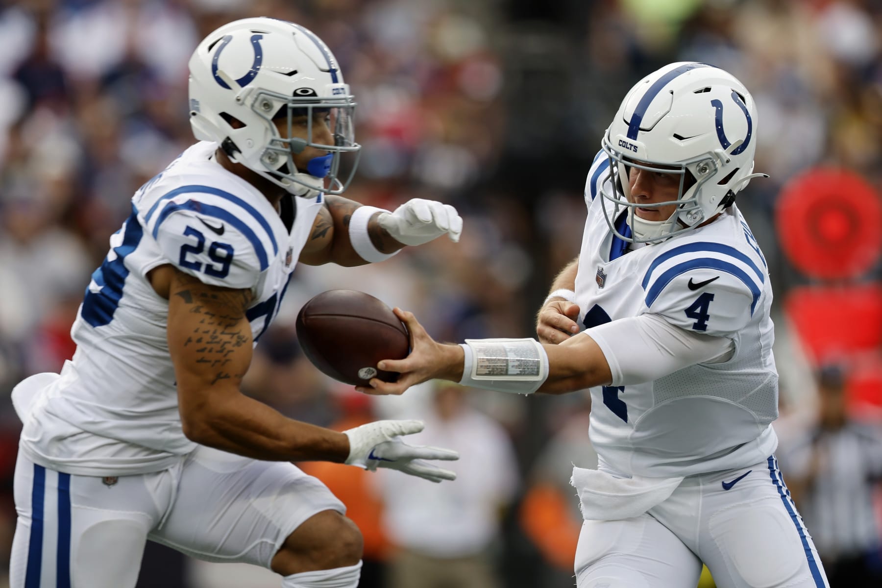Indianapolis Colts quarterback Sam Ehlinger (4) hands off to running back Jordan Wilkins (29) in the first half of an NFL football game against the New England Patriots, Sunday, Nov. 6, 2022, in Foxborough, Mass. (AP Photo/Michael Dwyer)