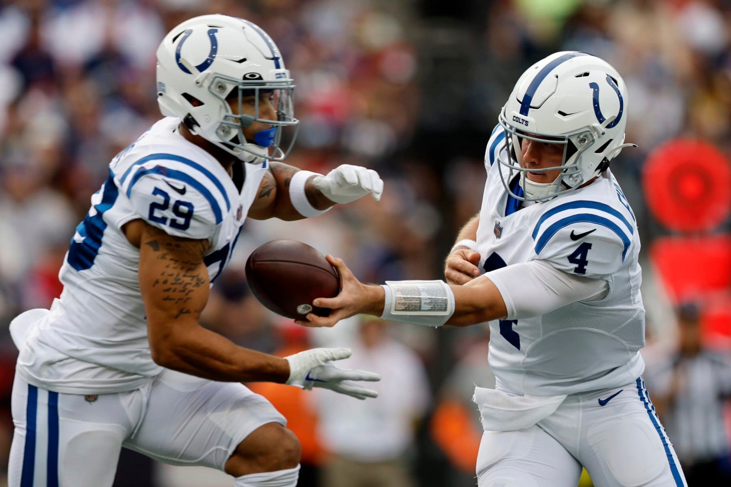 Indianapolis Colts quarterback Sam Ehlinger (4) hands off to running back Jordan Wilkins (29) in the first half of an NFL football game against the New England Patriots, Sunday, Nov. 6, 2022, in Foxborough, Mass. (AP Photo/Michael Dwyer)